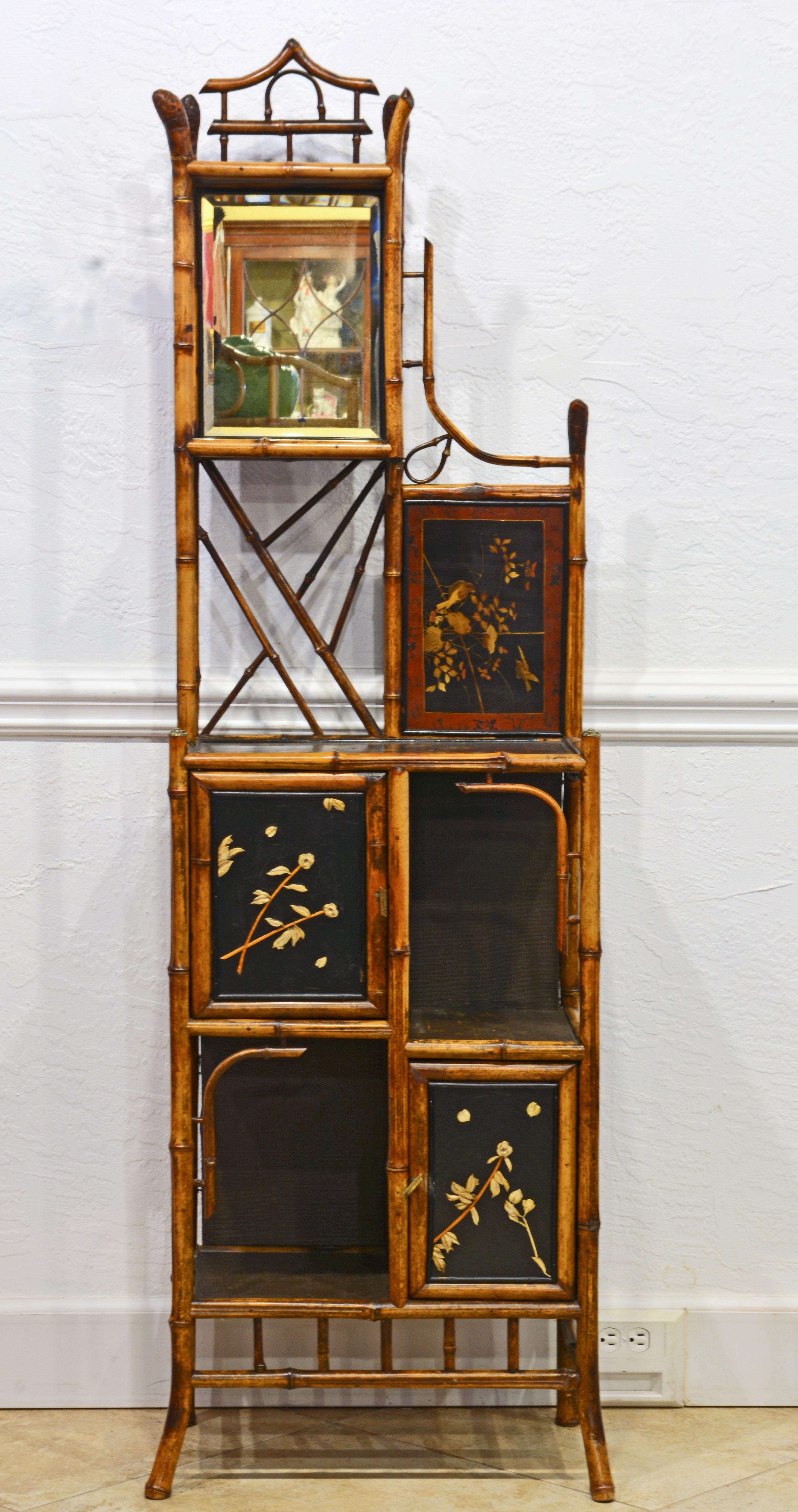 This English bamboo and lacquer etagere dating to around 1880 is fashioned with artistic details that links it to the Aesthetic Movement. It features an upper section with mirror, decorated panel and shelves above a lower section with two carved