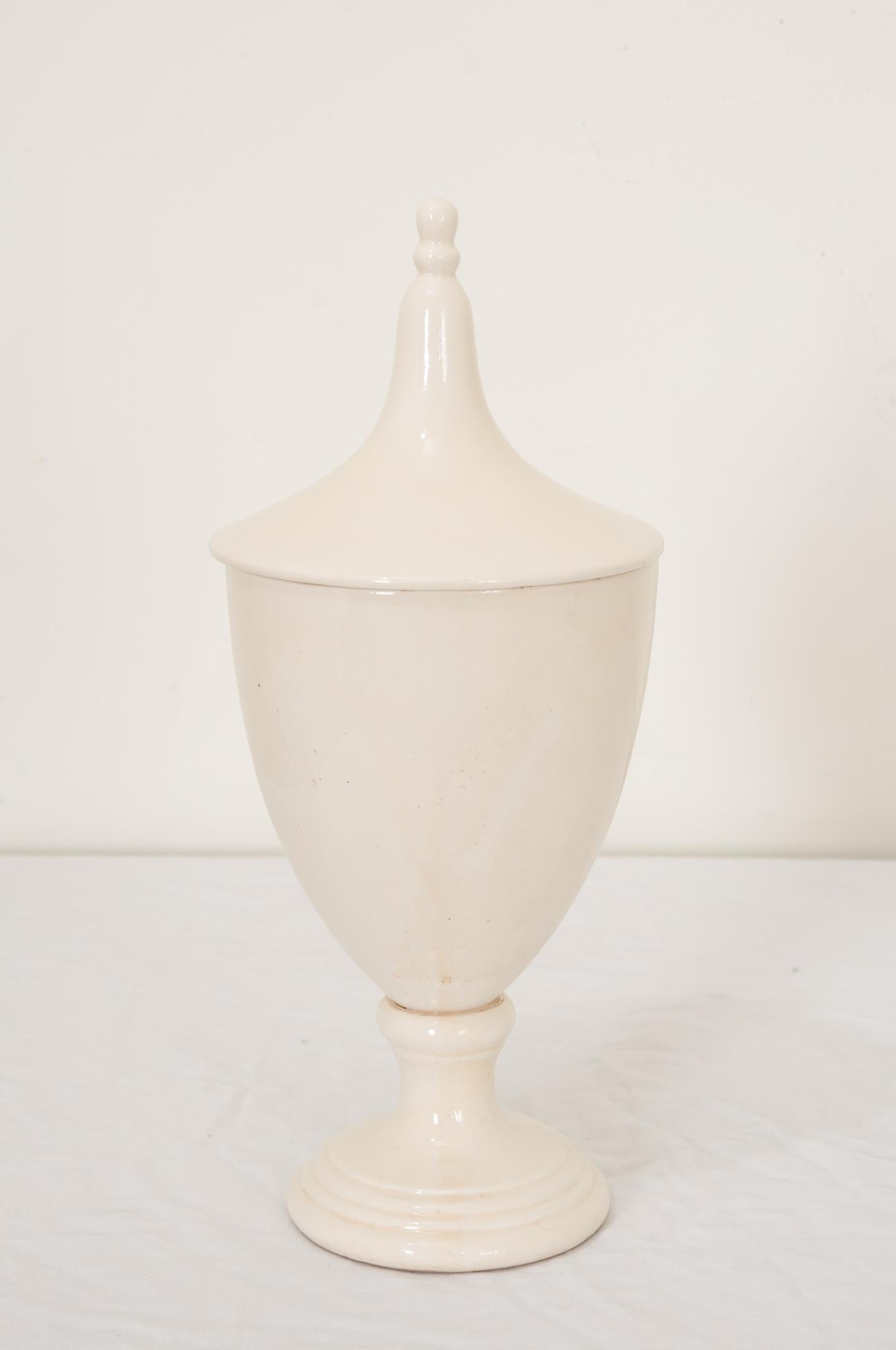 An English 19th Century apothecary or herbalist jar of white ceramic in the shape of a classical urn. Jars were used by apothecaries in pharmacies and dispensaries in hospitals and monasteries. Apothecaries needed containers to store herbs, roots,