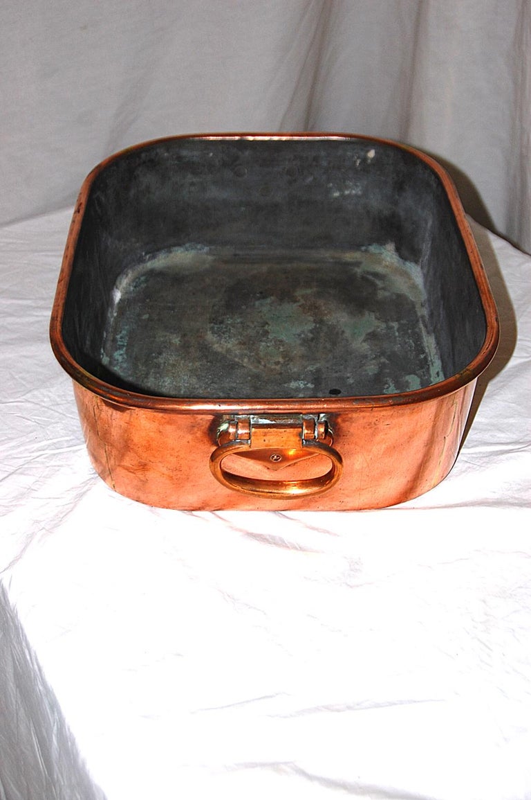 English 19th century copper dovetailed roasting pan with fine heavy cast carrying handles. The heavy quality of this pan was dictated by the army and navy specifications for cook ware. The cast handles are perfectly balanced for a laden roasting