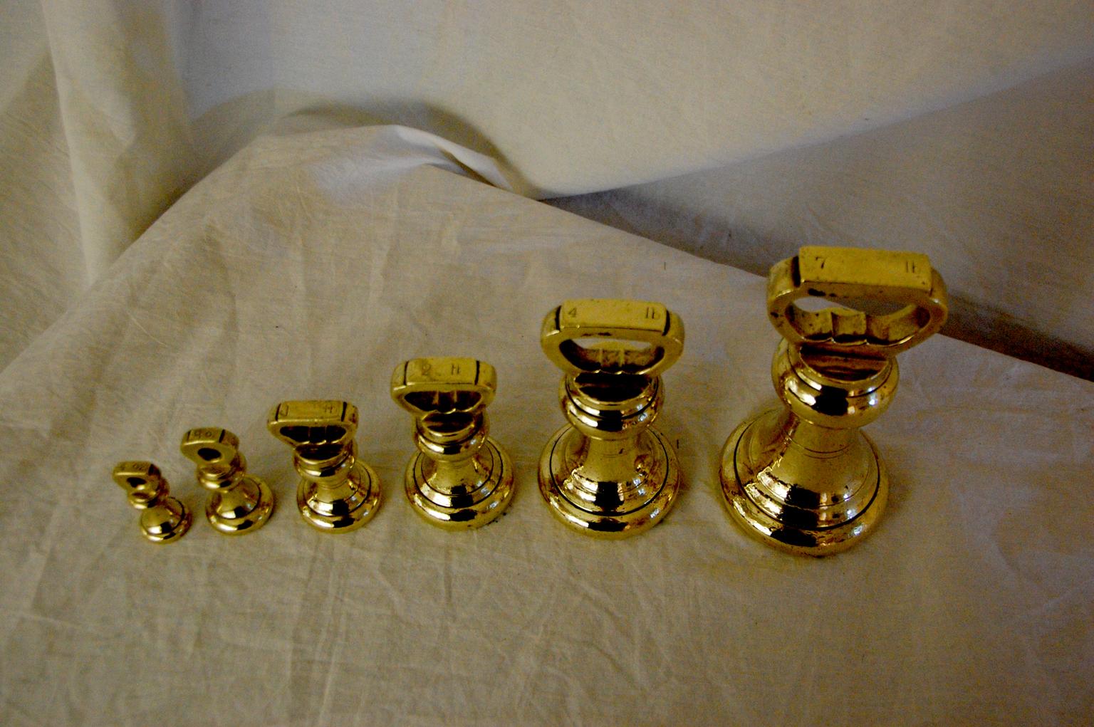 English 19th century assembled set of six brass bell weights. The six weights are 7 pound, 4 pound, 2 pound, 1 pound, 8 ounces and 4 ounces. These weights were used in retail establishments that sold items by weight. As such they were regulated by