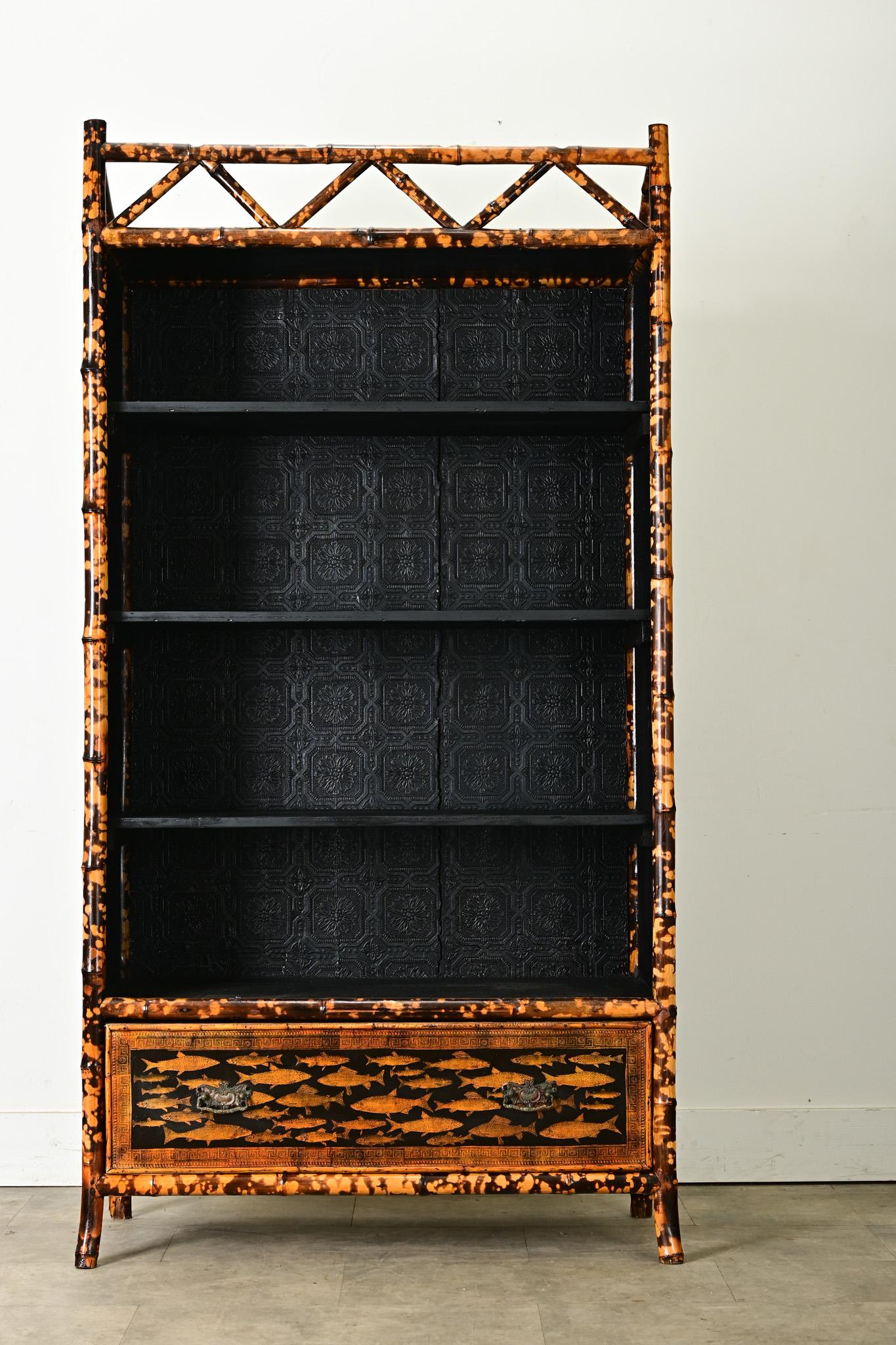 This English Victorian tiger bamboo bookcase from the late 1800s was given a creative update with recent decoupage and painted ebony finish. Schools of fish animate the exterior surfaces, their glowing honey color is a perfect match to the natural