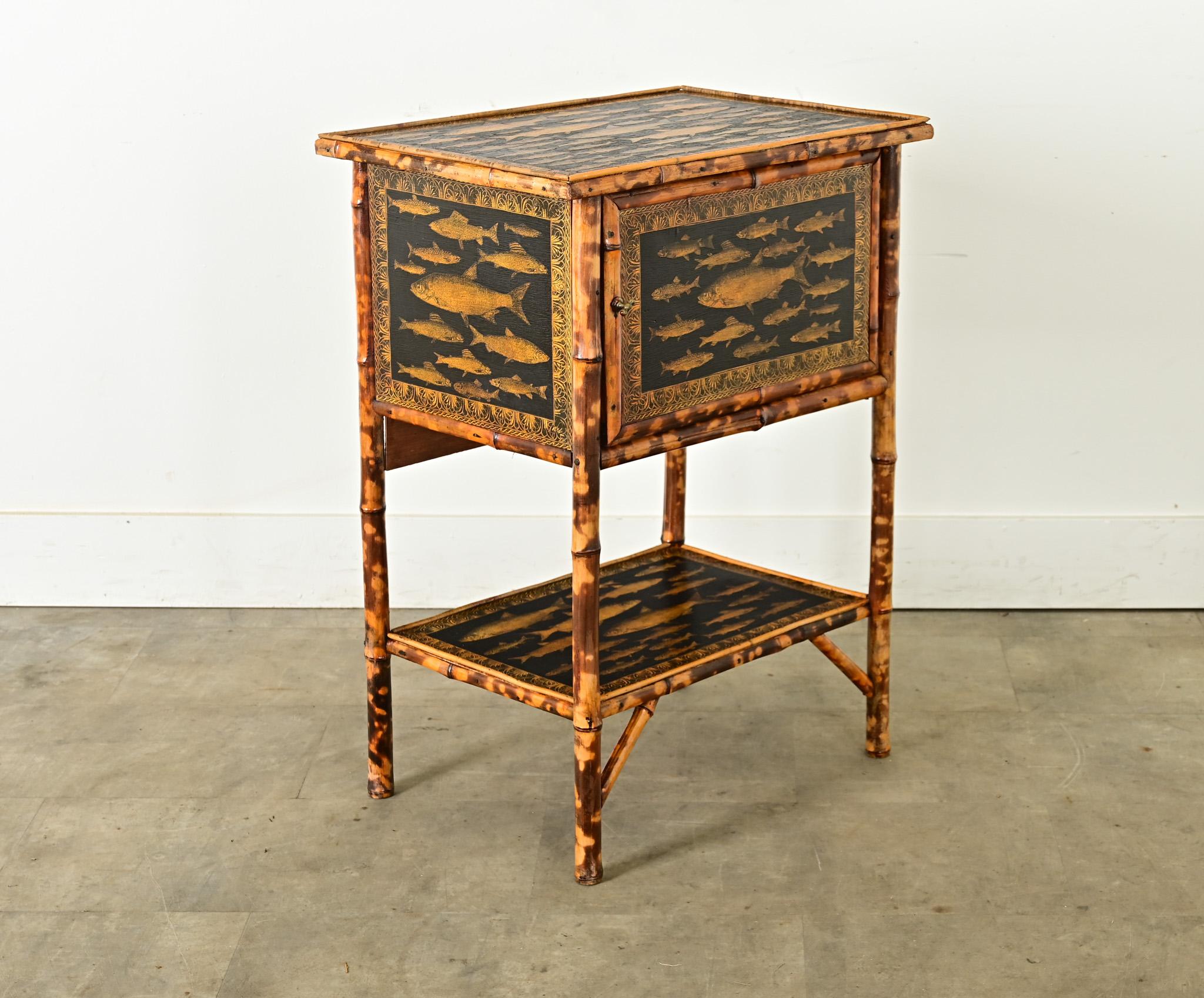 This late 19th century English Victorian Aesthetic Movement side table-cabinet has received an exciting update with recent decoupage as schools of fish! The exotic bamboo frame complements the honey-gold illustrations, which are affixed to ebonized