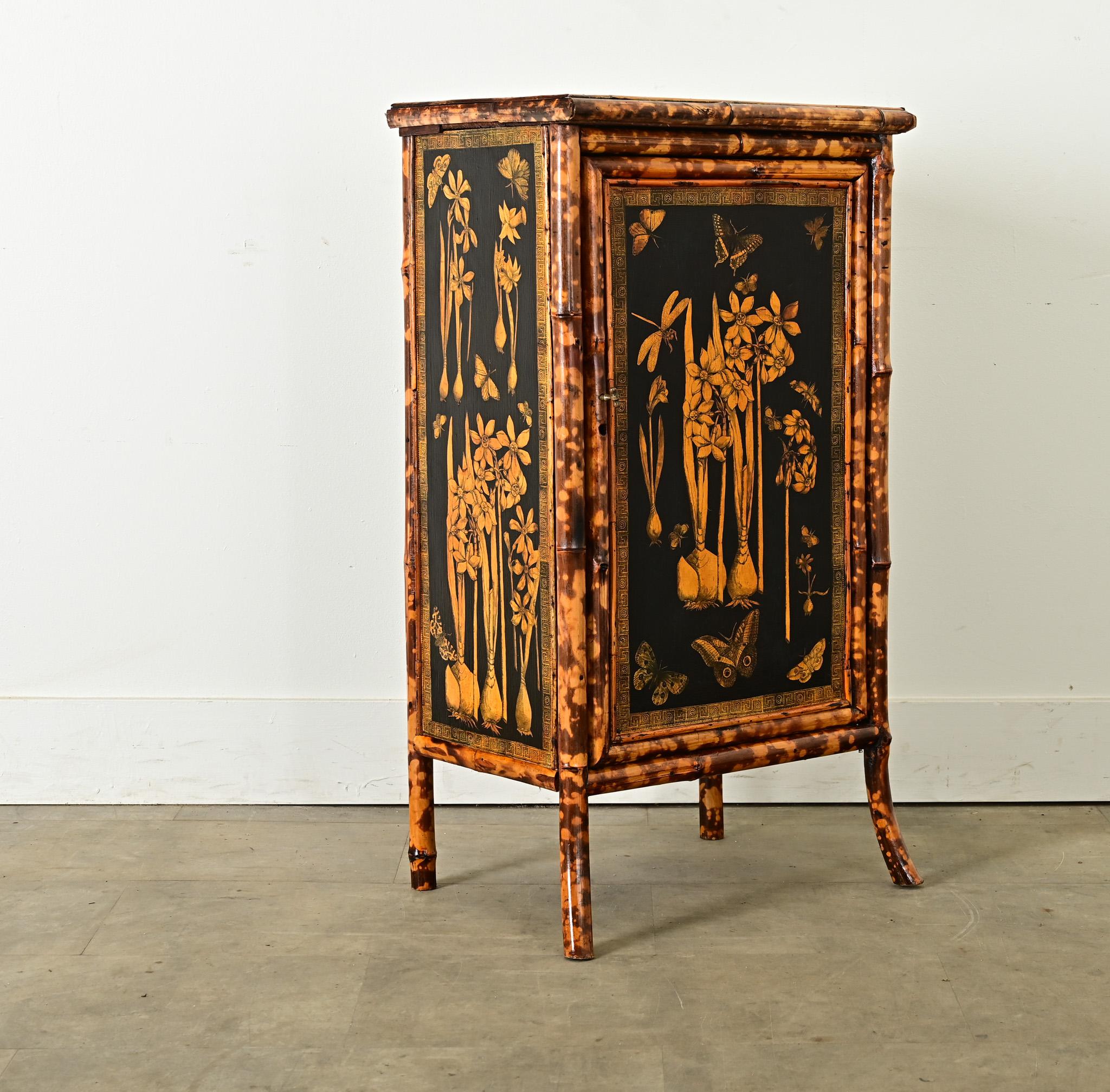 This late 19th century English Victorian Aesthetic Movement cabinet has received an exciting update with recent garden-themed decoupage finish. Golden yellow illustrations of butterflies and flowering bulb plants, applied by hand to an ebonized