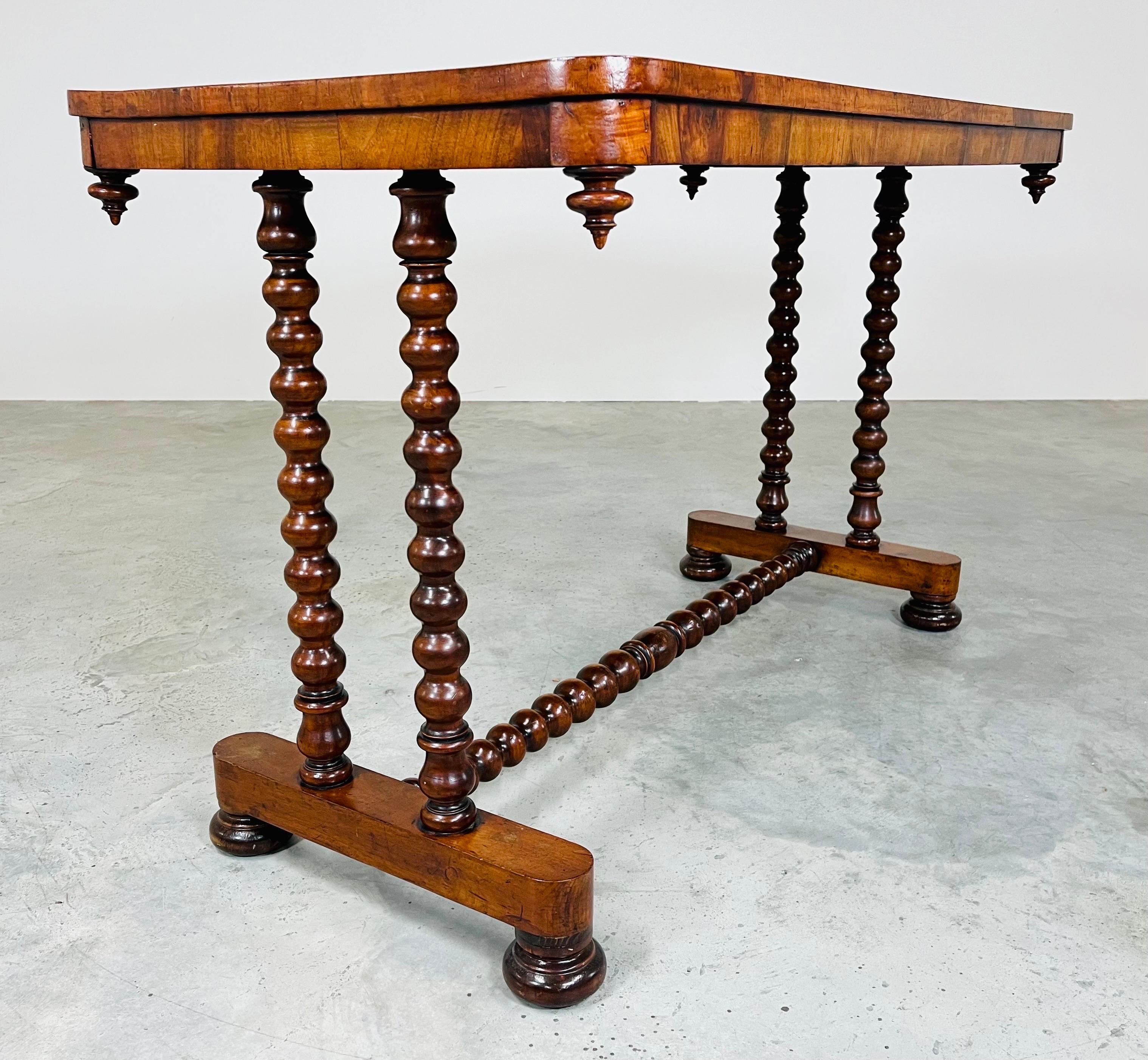A stunning Mid-19th Century desk or console table having turned mahogany legs and frame with outstanding grain on the top adorned with inverted finials on the aprons corners. 
In fantastic vintage condition having been well maintained and treated