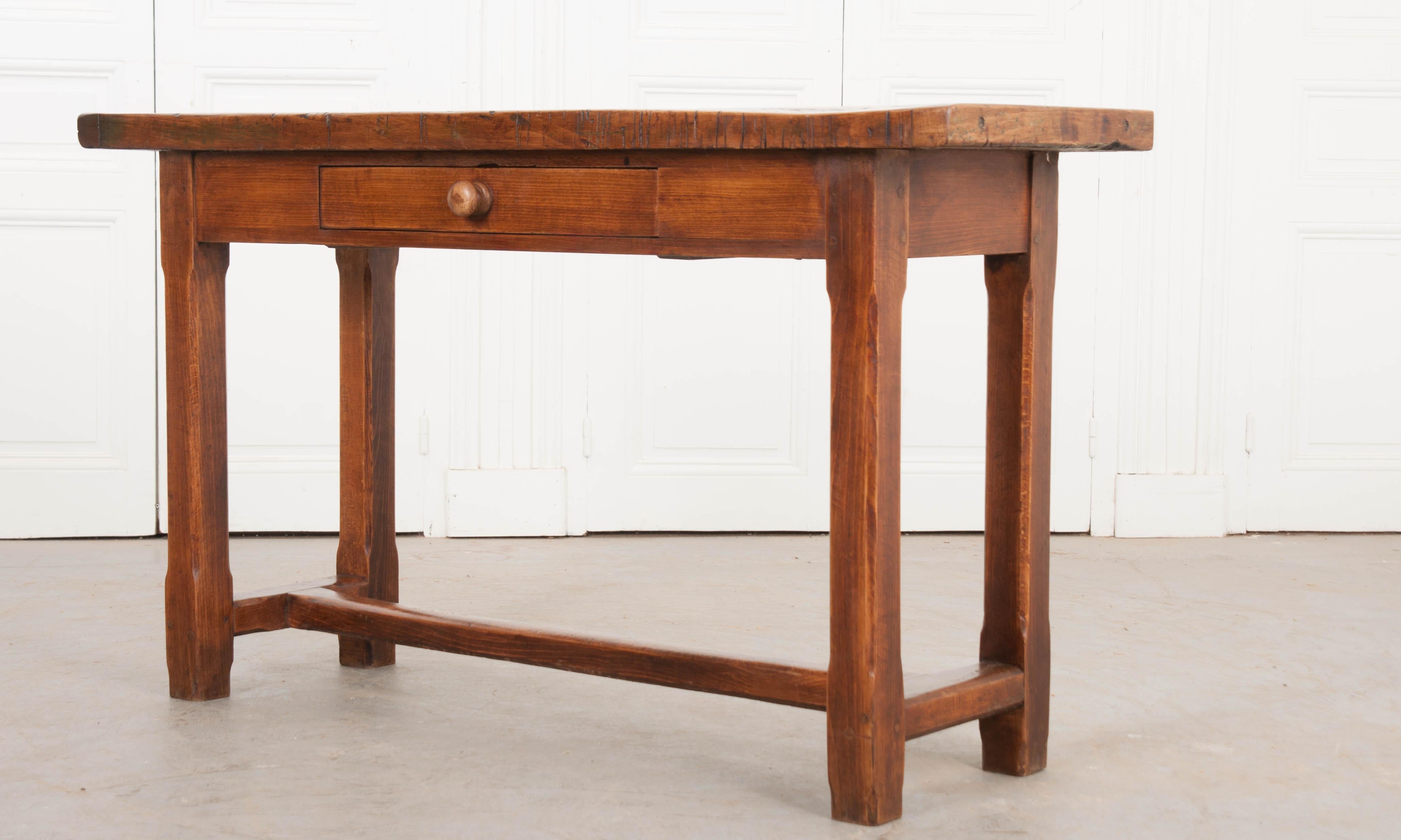 This wonderful English beech server, circa 1860, features a thick two-plank surface above an apron outfitted with a single drawer with a turned pull, raised by square chamfered legs and having an H-form stretcher. This server would work well in a