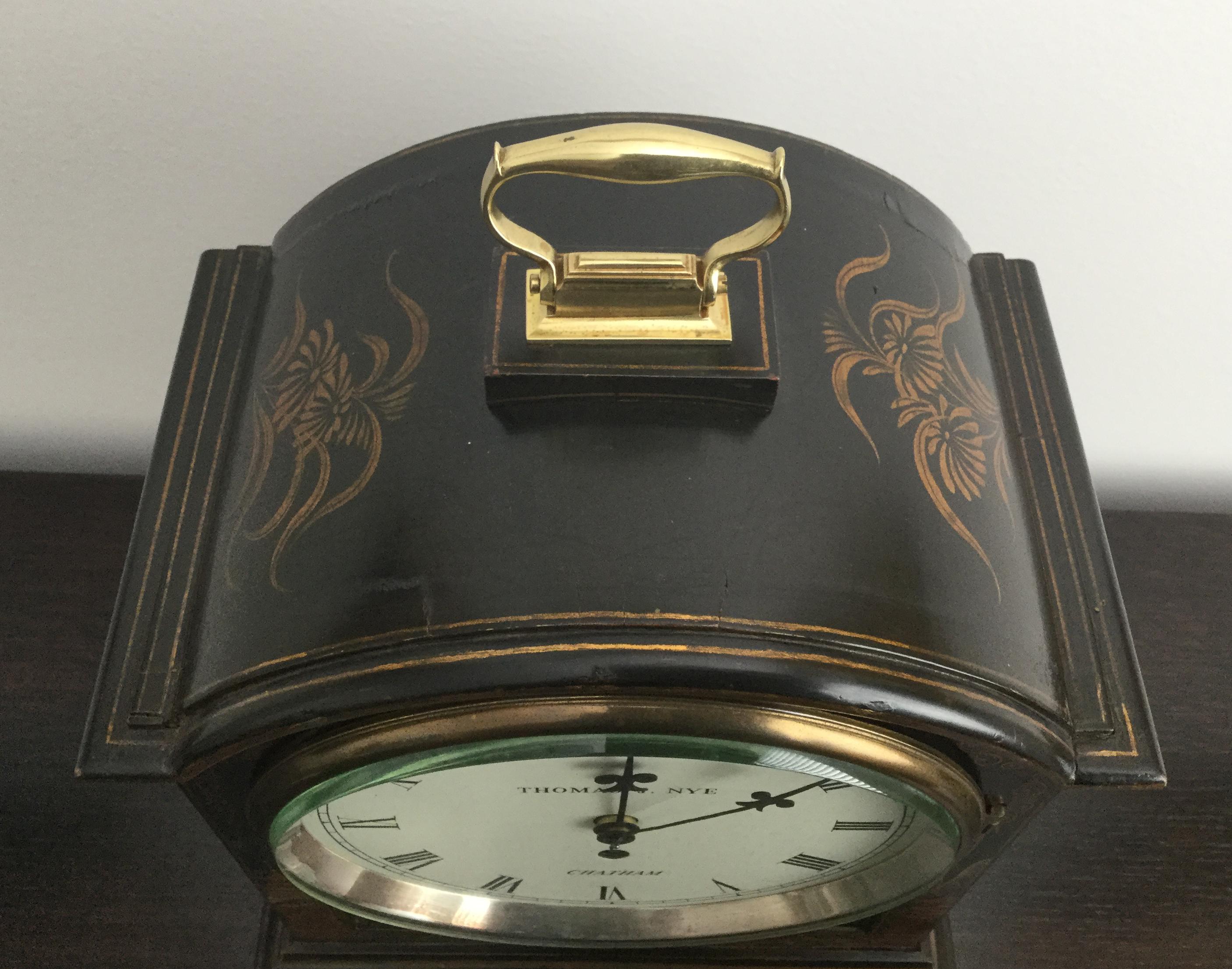 An attractive black chinoiserie decorated bracket or mantel clock, the wooden case profusely decorated in relief with garden scenes, figures, pagodas and floral motifs, the top with brass handle, on brass ogee feet.

The white painted dial with