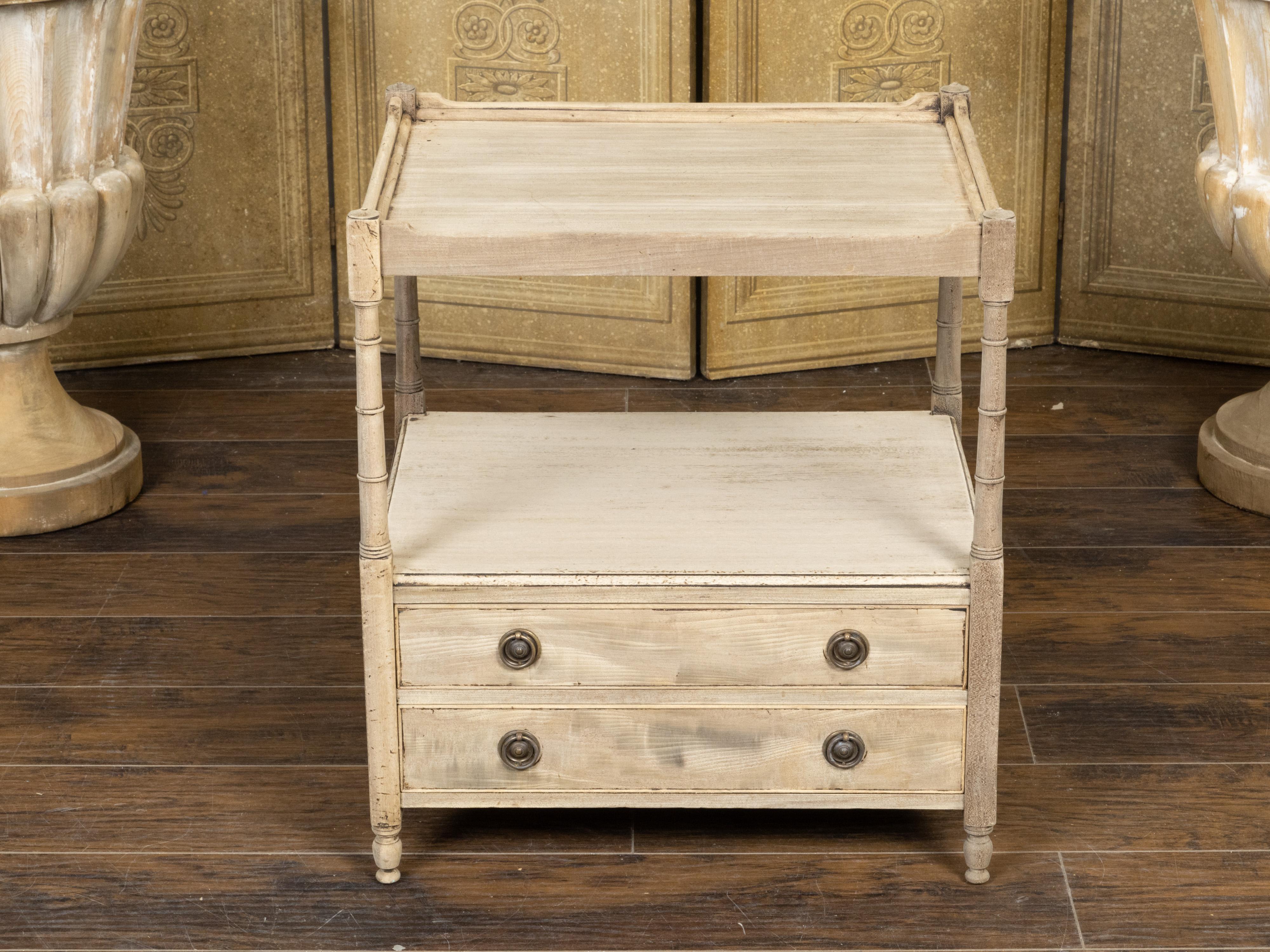 An English bleached mahogany end table from the 19th Century, with open shelf, two drawers and classical brass hardware. Created in England during the 19th Century, this mahogany end table features a bleached finish complimenting its clean lines