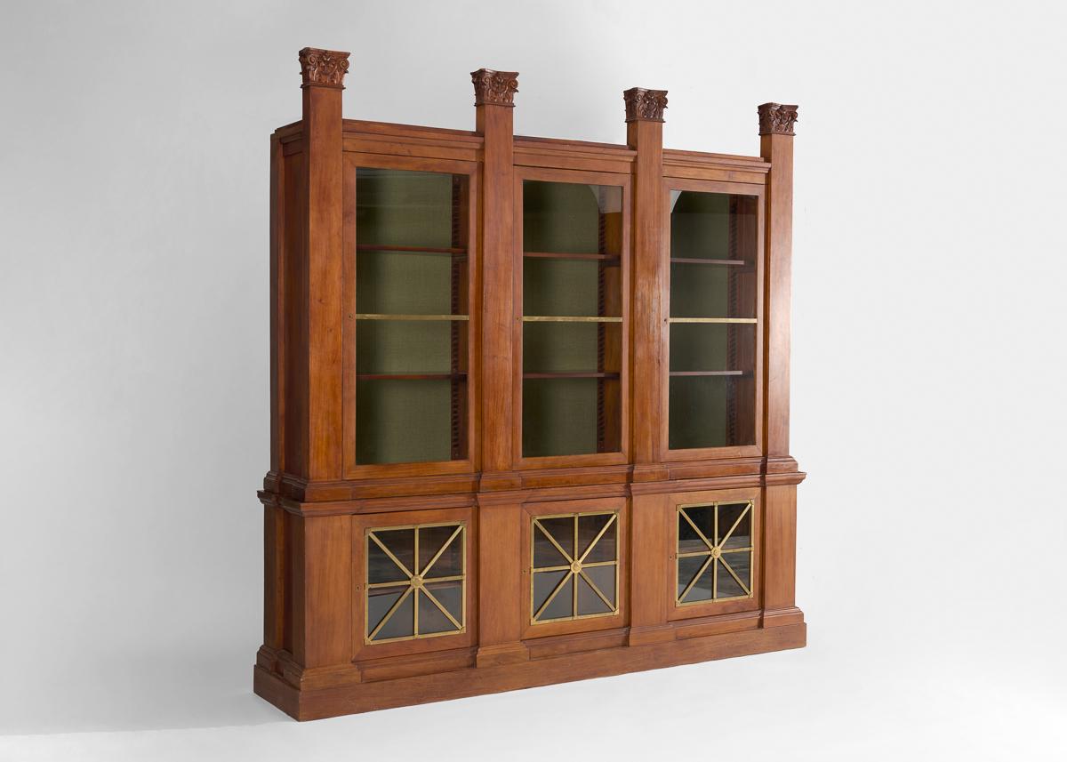 In stile neoclassico del XIX secolo, questa grande libreria contemporanea è sormontata da capitelli corinzi. Sei ante in vetro si aprono per rivelare i ripiani sopra e sotto. Questo pezzo proviene dallo studio di architettura di Thierry W. Despont,