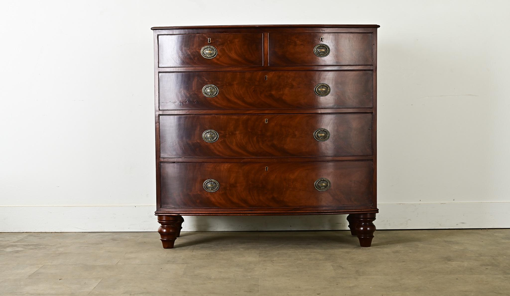 A classic English bow front chest made of mahogany in the Regency period, circa 1870. The top surface is cut from a single plank, and finished by a low, routed edge. Richly grained mahogany with signature flame pattern, is a perfect match for the