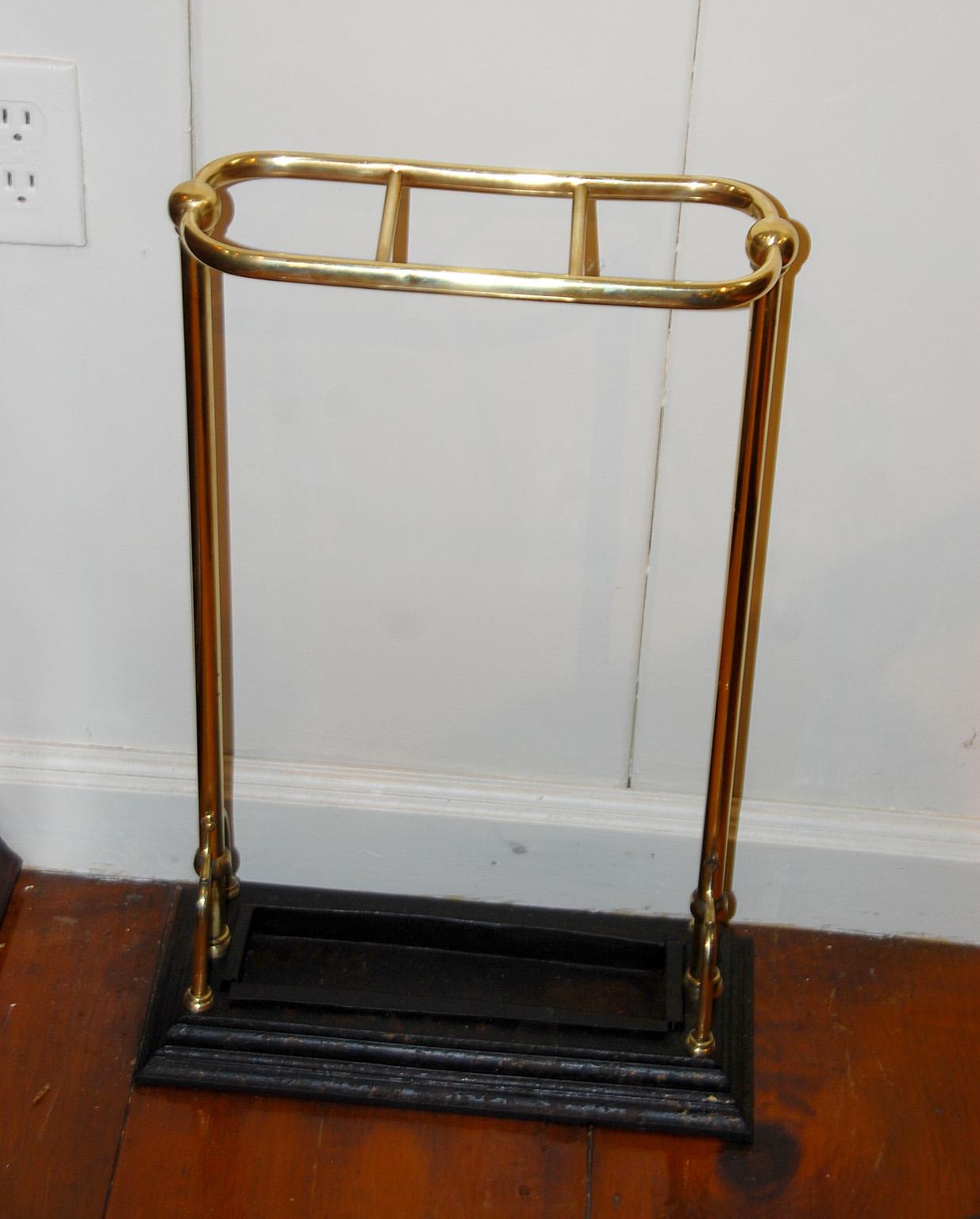 English 19th century brass and iron umbrella or stick stand. This compact walking stick stand or umbrella stand is registry dated 1884. The cast iron base is painted black, as is the removable iron drip pan.