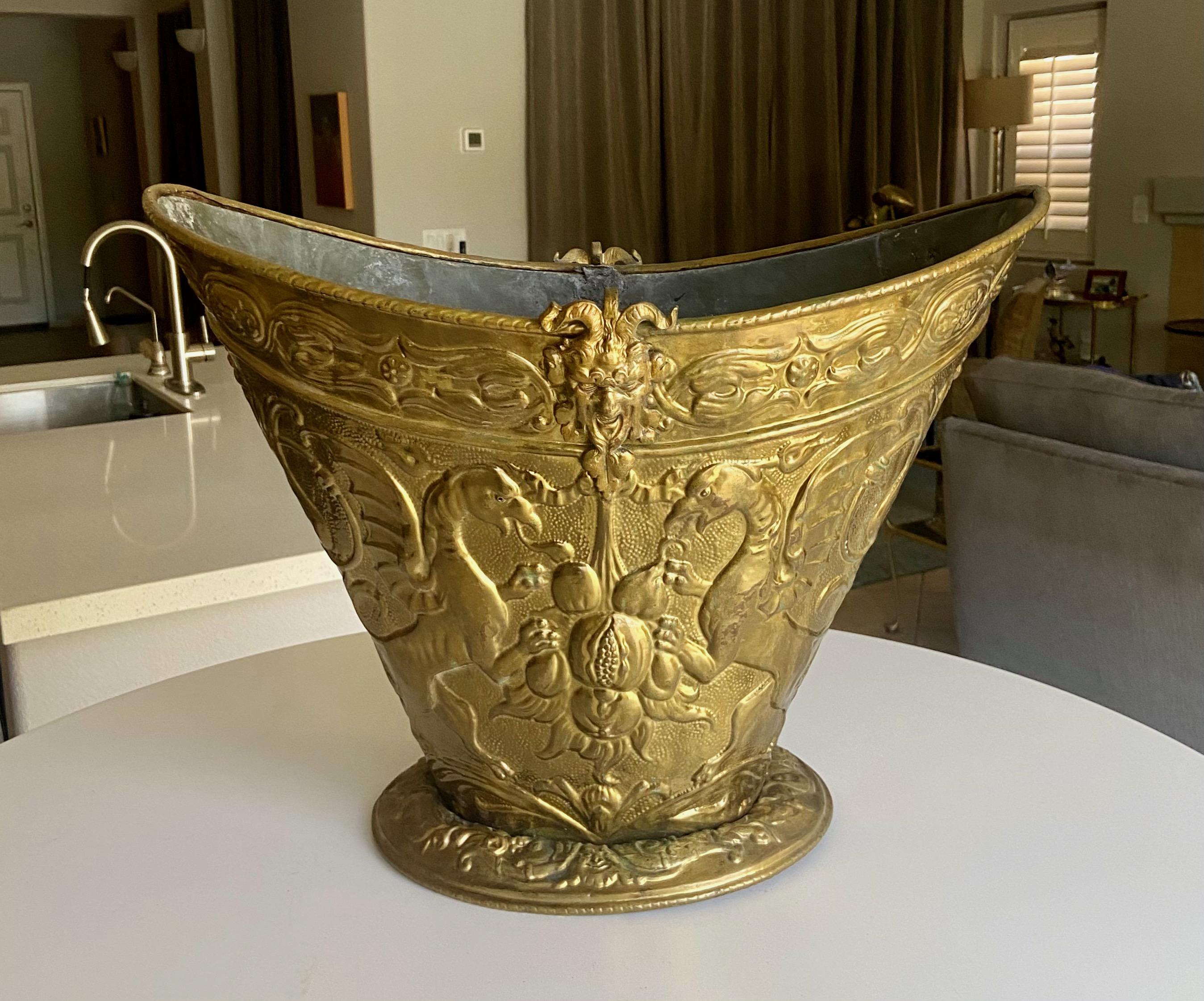 English 19th century Period embossed brass Jardinière or fireplace log bin with Satyr and dragon motif figures. Finely detailing throughout. The interior is lined in lead. No handles. 