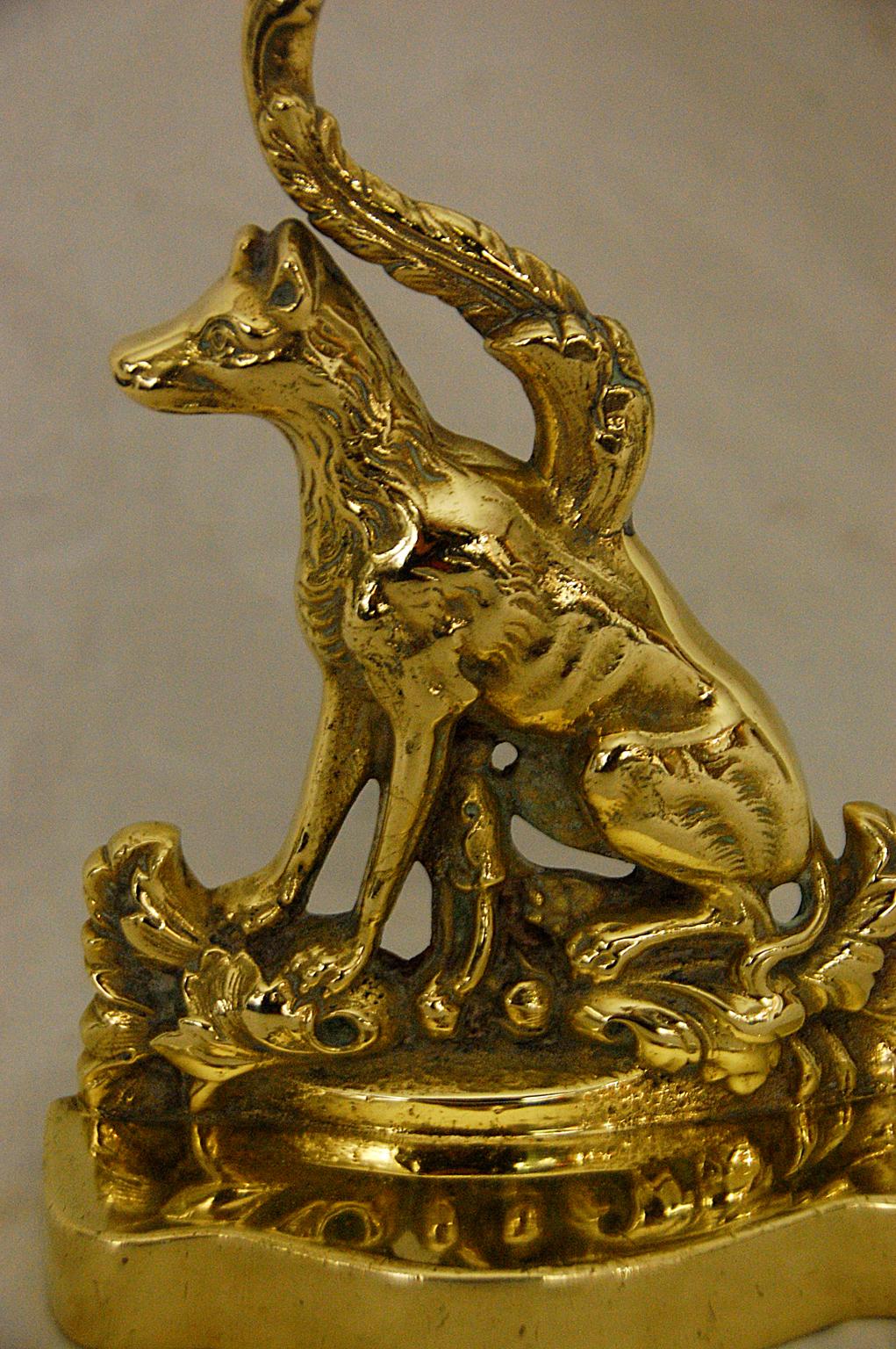 English 19th century cast brass sitting dog doorstop with vine handle and lead weighted brass base. This crisply cast dog doorstop is exceptionally easy to move with its brass leaf and vine handle. The serpentine cast brass base is filled with lead