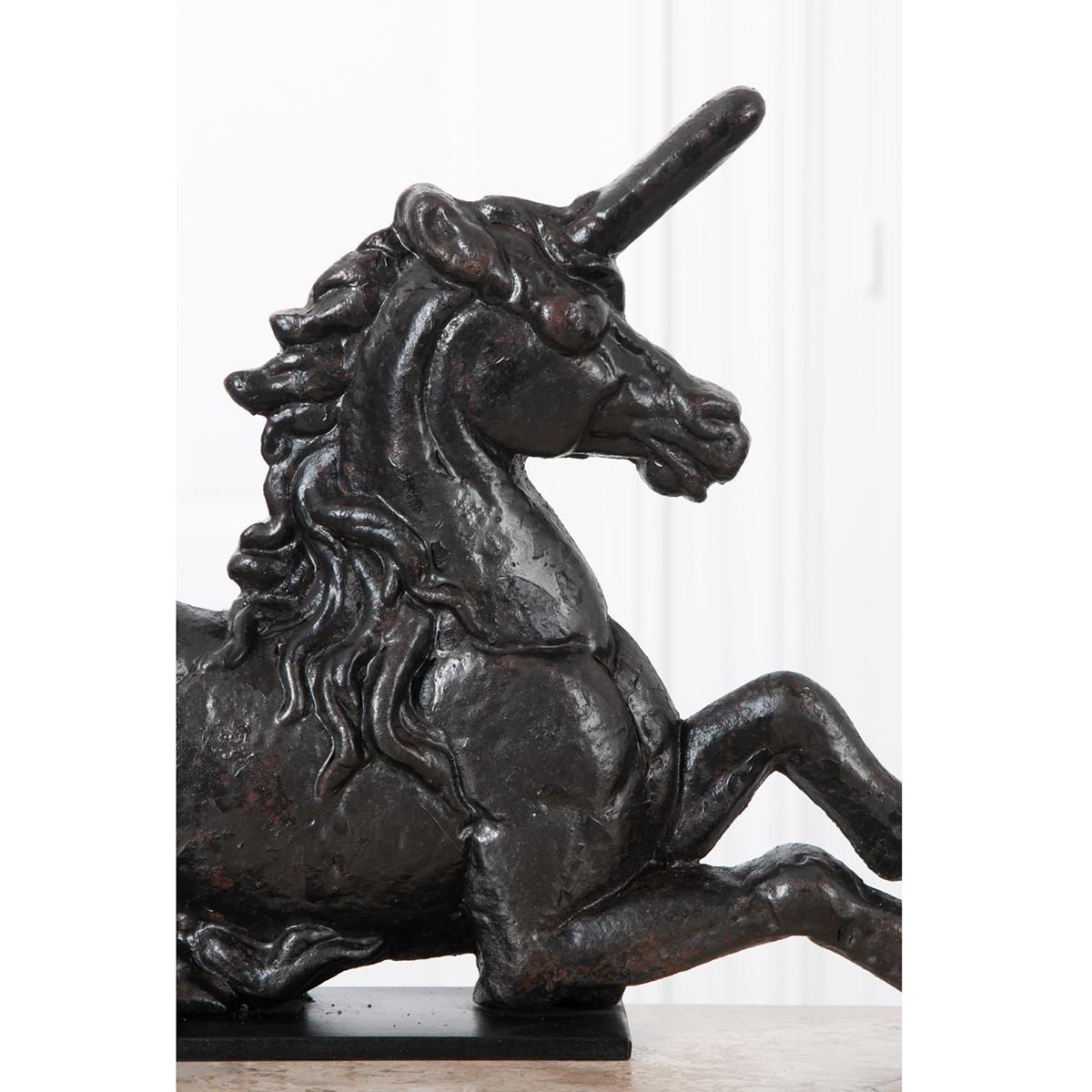 A large, cast iron unicorn with a custom attached base stand. Great detail can be seen in the creature’s mane, head and musculature.