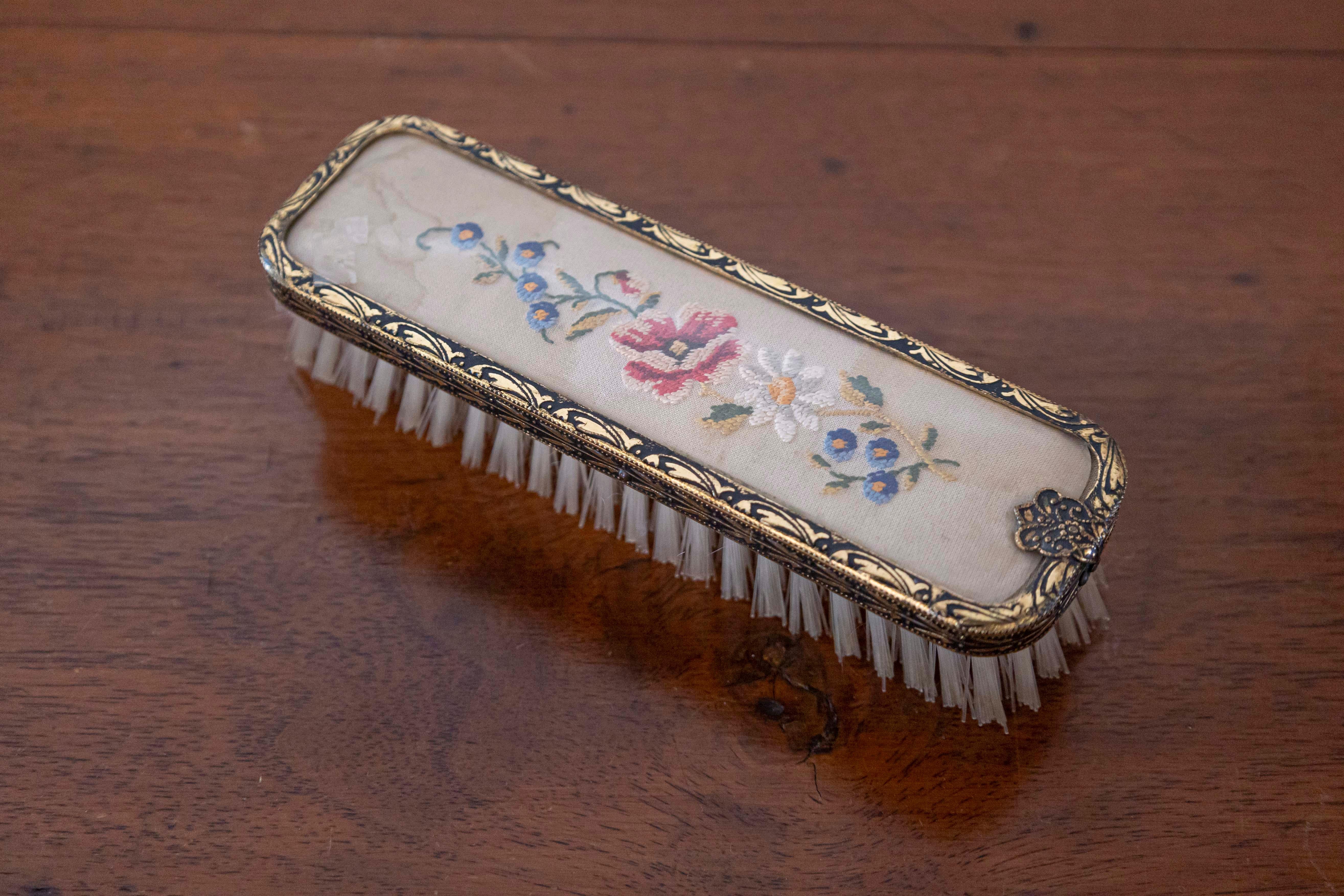 An English clothes brush from the 19th century, with petit point décor on silk and brass borders. Born in England during the 19th century, this sweet rectangular clothes brush features a lovely petit point floral décor on silk, presenting white,