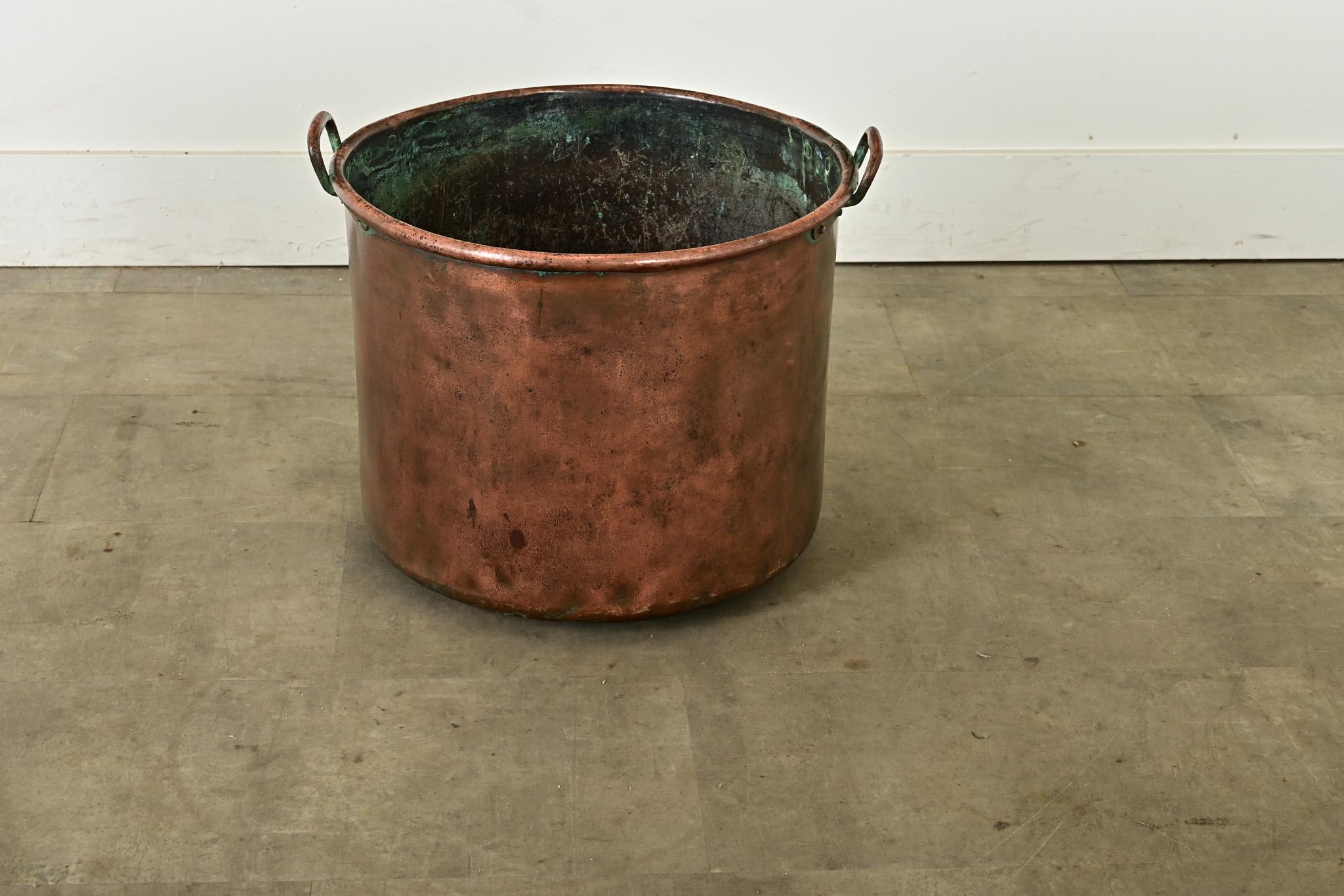 Importante marmite anglaise en cuivre, avec deux anses étroites sur le bord, datant d'environ 1850. L'extérieur présente une patine profonde, qui donne aux bosses et aux creux une teinte marron, tandis que l'intérieur est plus fortement oxydé et