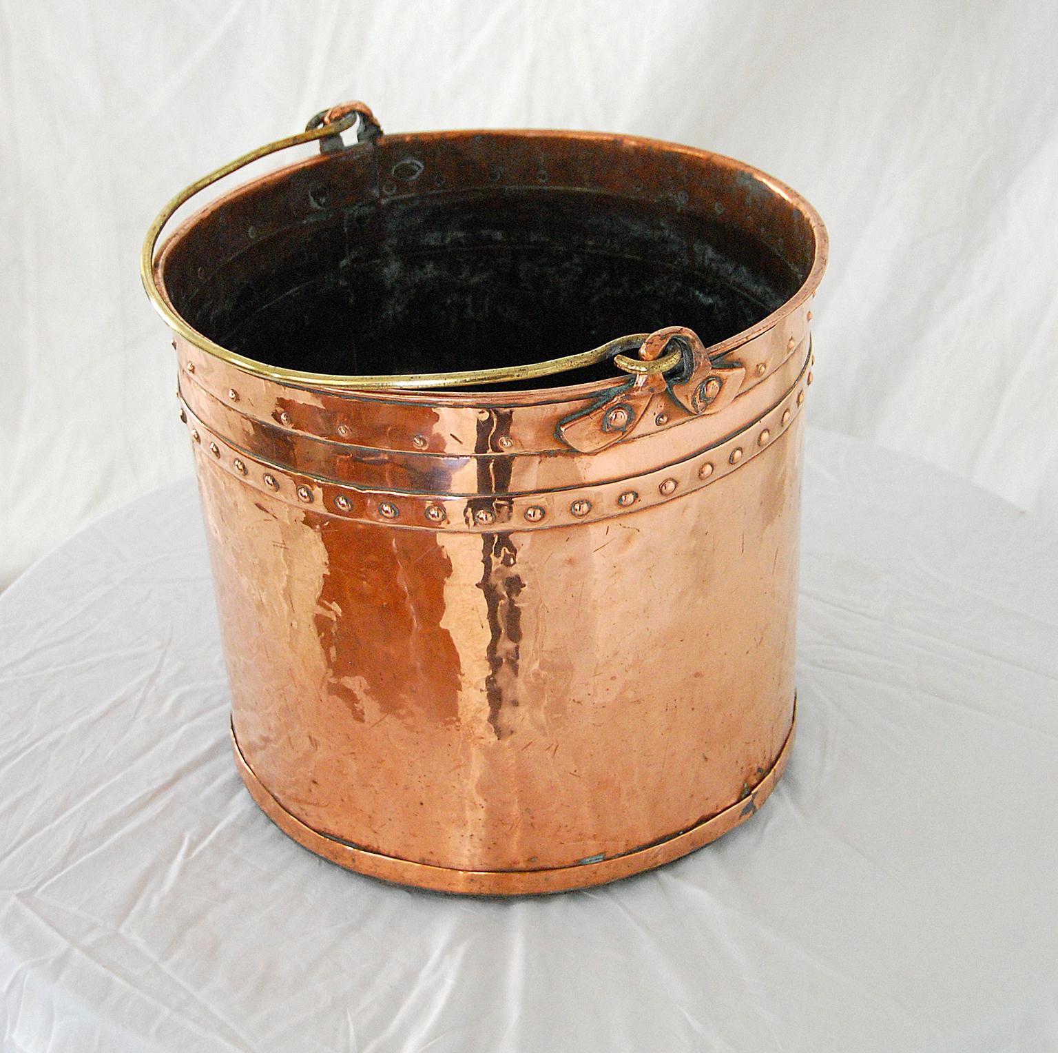 English 19th century copper riveted construction 14 inch coal or ash bucket with brass swing handle. In the Victorian era the maids would use this bucket to bring coal to the fireplace or to take away ash from the fireplace. Today this form is often