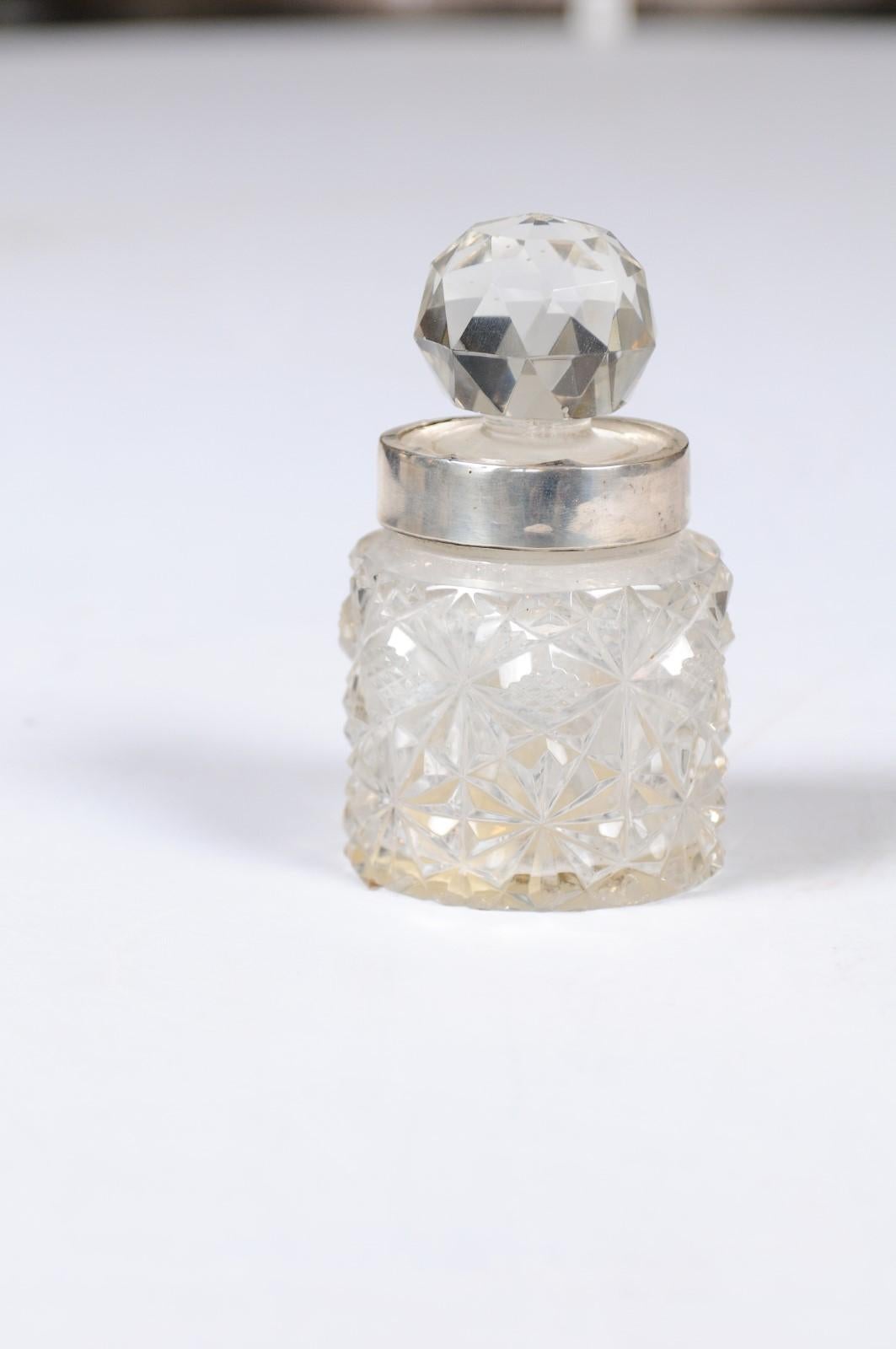 A small English crystal jug from the 19th century, with silver neck and round faceted stopper. Born in England during the 19th century, this lovely petite jug features a circular body adorned with diamond-shaped motifs, while a silver neck supports
