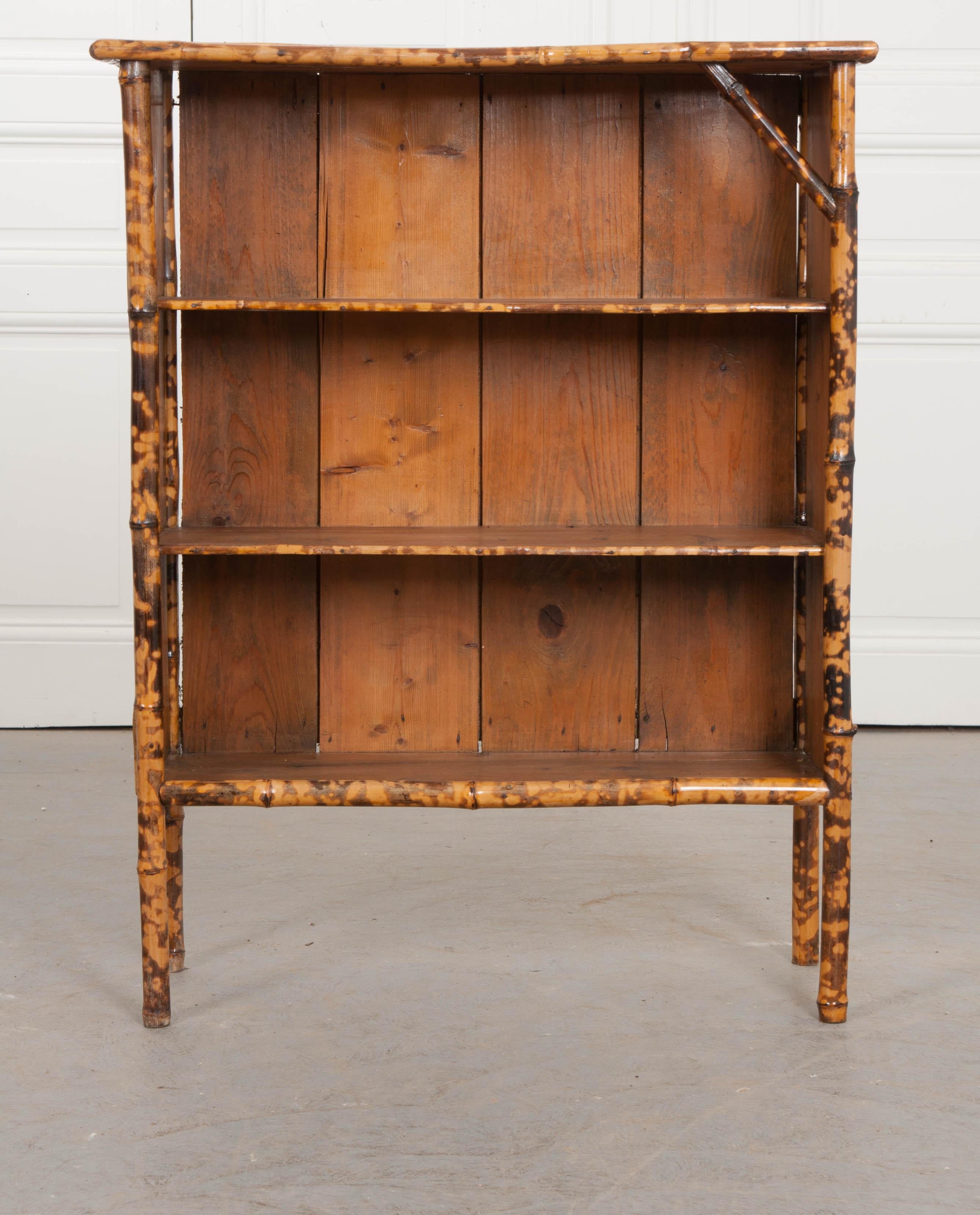 A darling English bamboo bookshelf, circa 1890s. Being recently refinished, fabulous fish découpage, interesting borders, and exposed wood have replaced the original damaged seagrass. This small bookcase has two center shelves. Sturdy and ready for