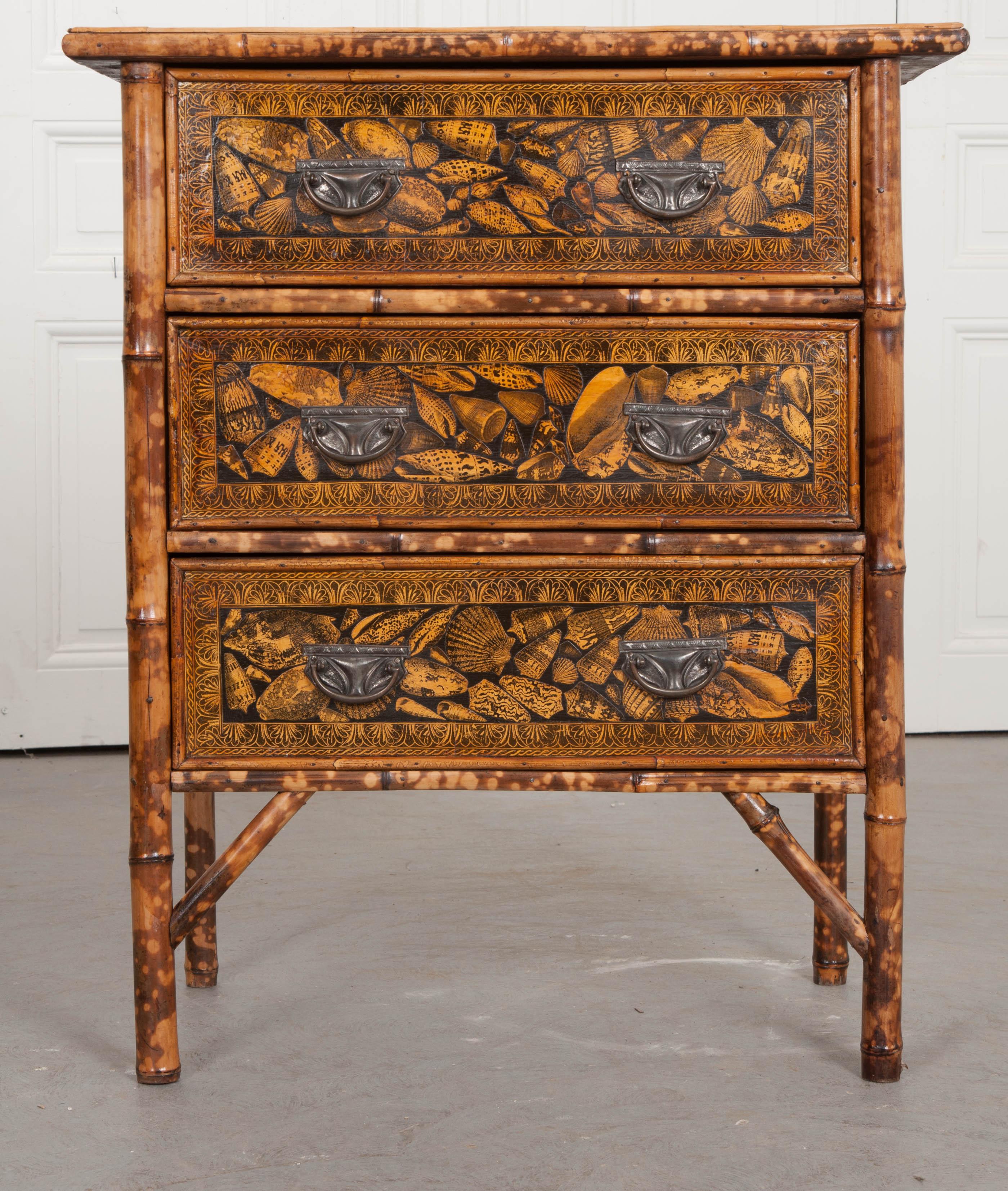 An English three-drawer bamboo chest from the 1890s that has been recently refinished. Where you see decoupage is where seagrass matting once was. The seagrass has been damaged and replaced with this fabulous shell decoupage and interesting