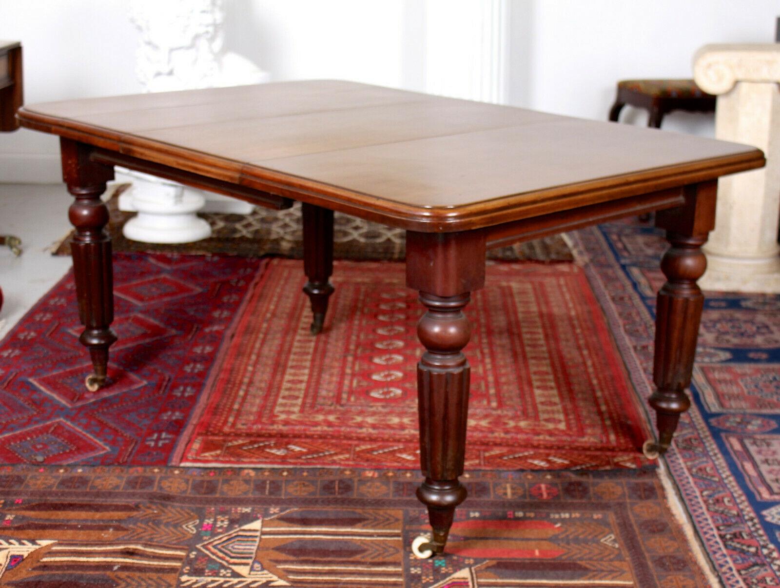 An impressive 19th century telescopic dining table.
The top - with rounded corners and chamfered edges - extending by way of spare leaf. Complete with the original winder and Joseph Fitter mechanism. Raised on well carved turned and fluted legs