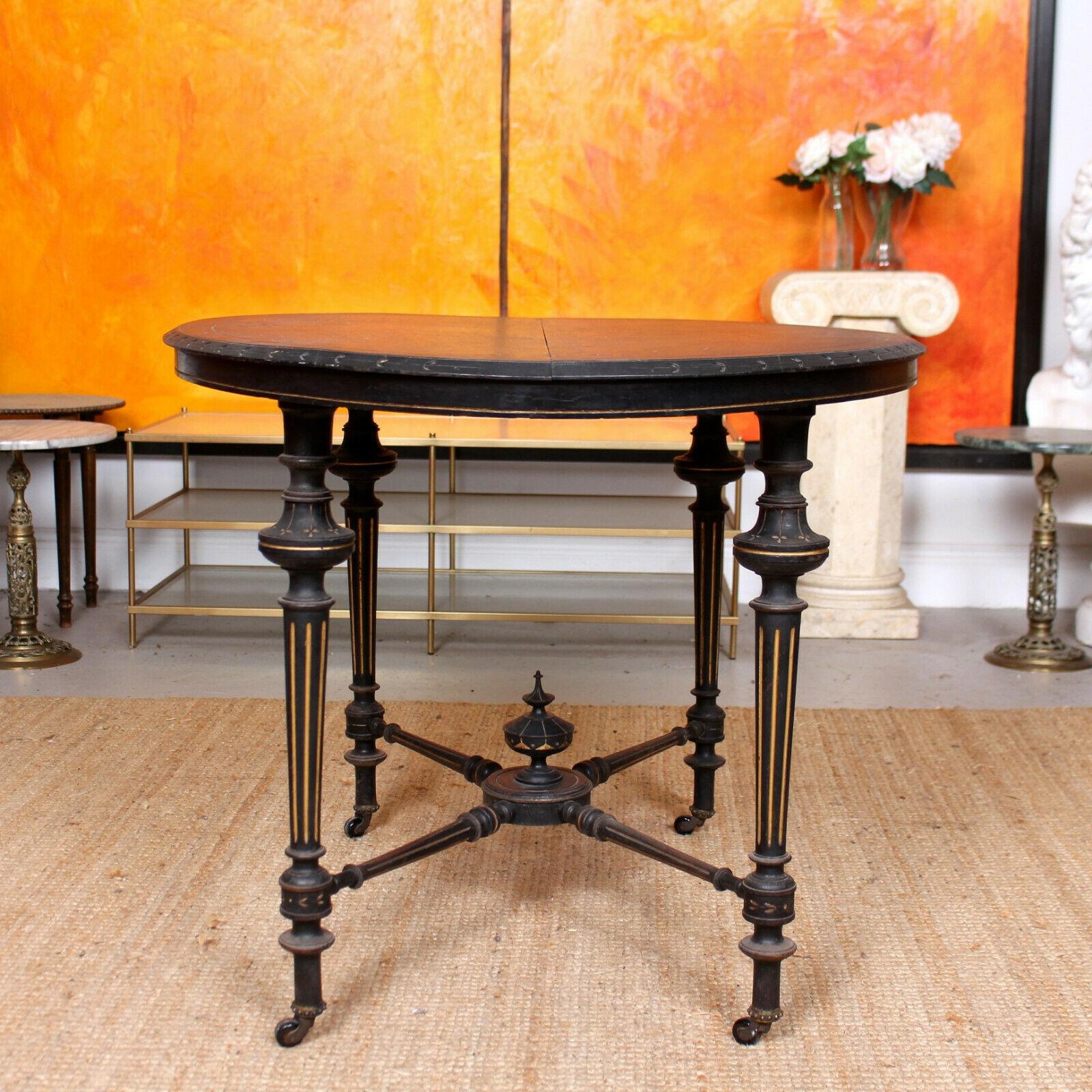 An impressive 19th century ebonized table.

The oval top with decorative carvings to the surface and chamfered edges. The gilt edged beaded apron raised on fantastic carved and gilt tooled turned tapering fluted leg terminating in castors and
