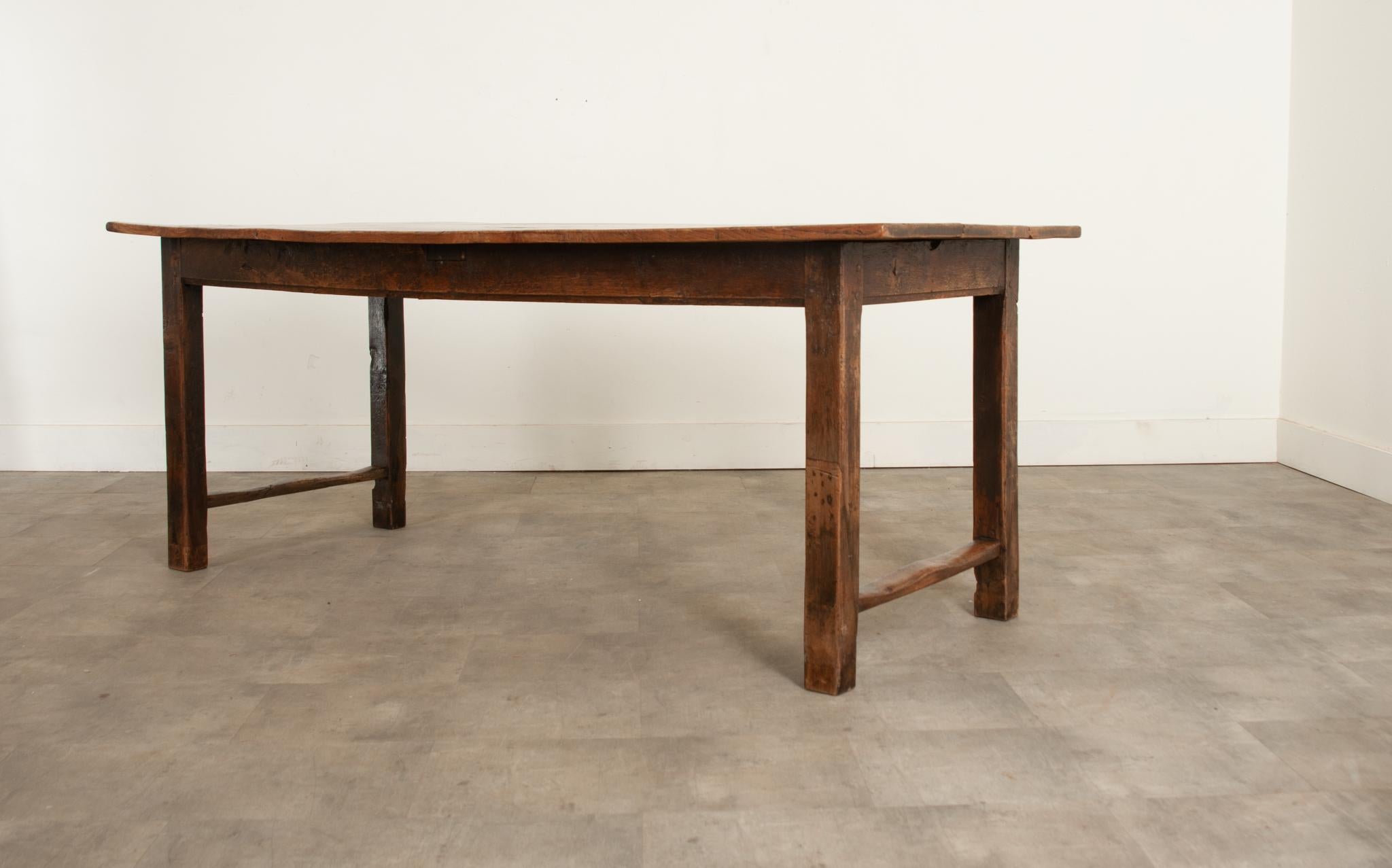 A very early 19th century English farmhouse table made from elm and ash. The top is made from solid elm planks supported on an ash base, which has a simple apron that follows down to streamlined and well supported squared legs. This table is well