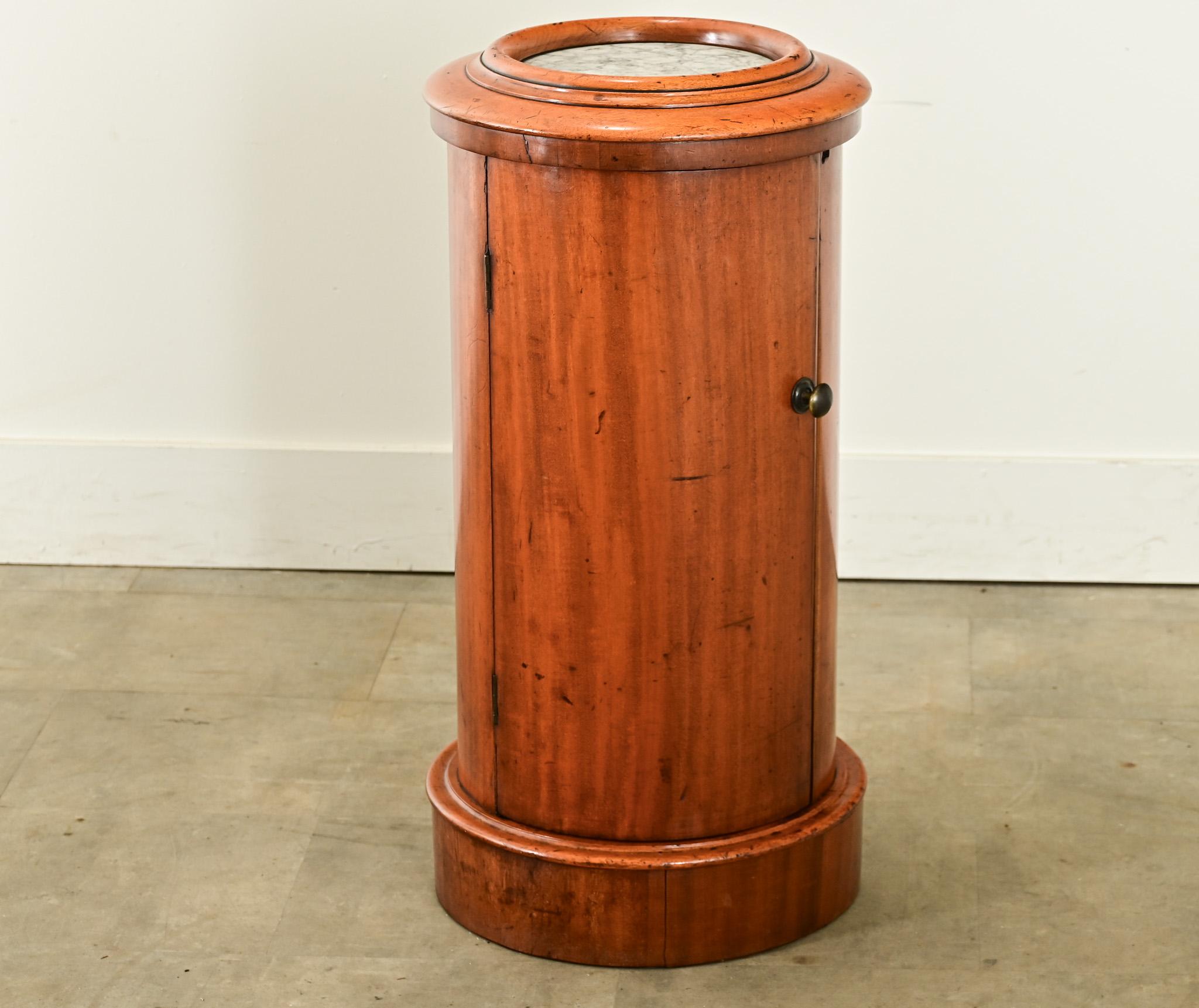 A fantastic little 19th century English pedestal for a bedroom, powder room or wherever you need a little table. Crowned with a marble top set within concentric rings of molding, the fruitwood cabinet is cylindrical in shape with a door opening by a