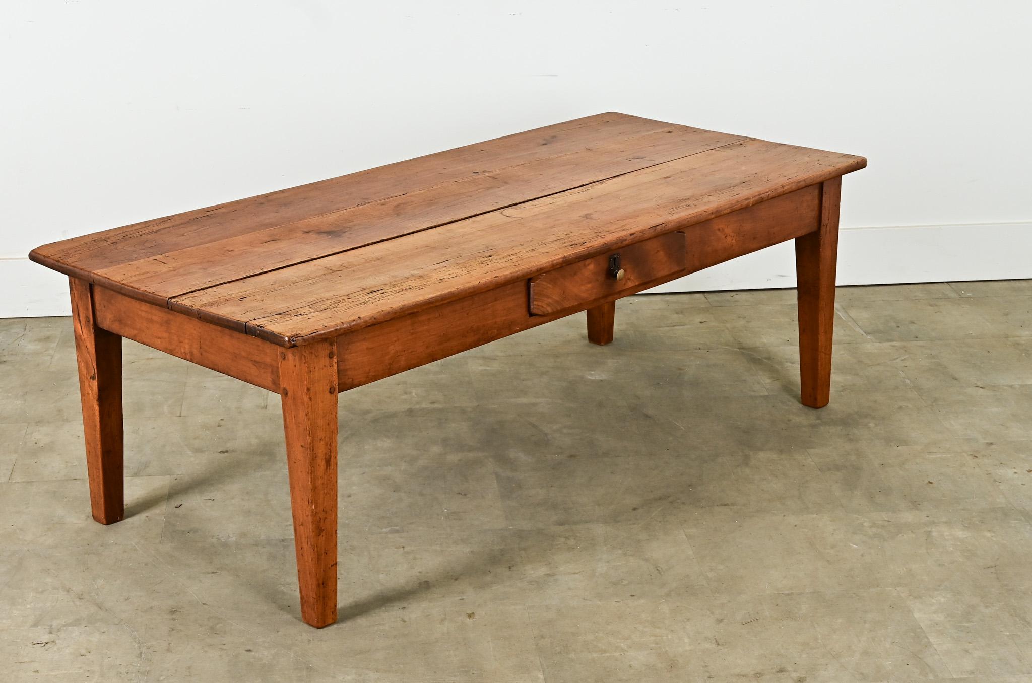 Une table basse anglaise en bois fruitier massif avec de belles veinures ferait une table basse parfaite. Le plateau en planches repose sur le cadre de la table avec un seul tiroir et des pieds effilés. Nettoyée et polie avec une cire en pâte, cette