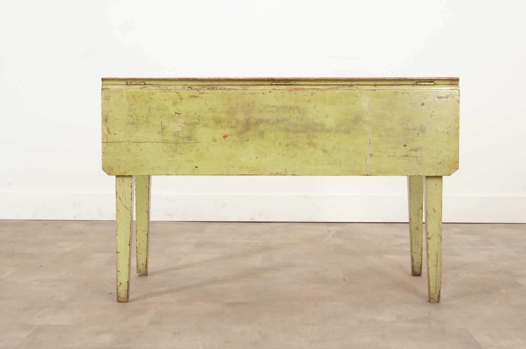 This gardeners work table from 19th century England is a fantastic way to add a rustic pop of color to your space. The worn lime colored paint bears the marks of much use over the last two decades, giving it tons of antique charm. The front drop