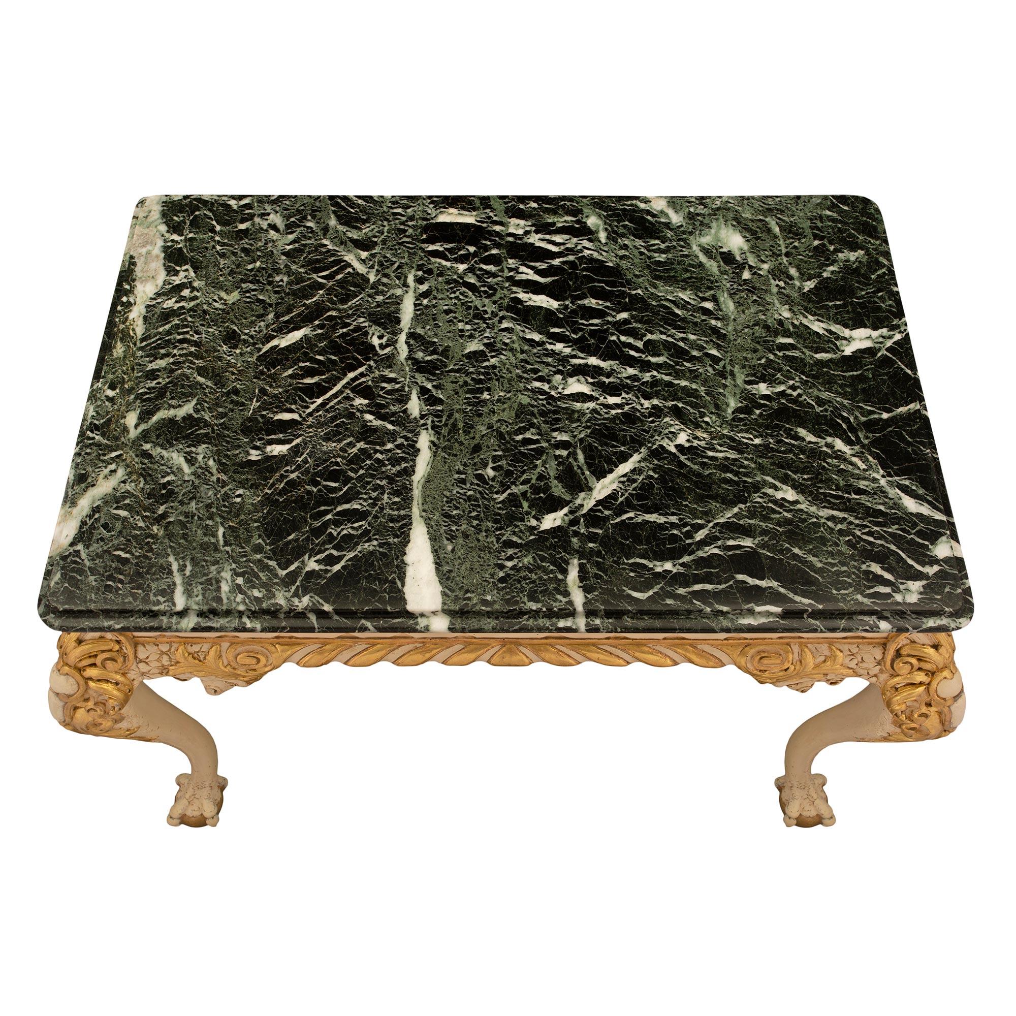 A striking English 19th century George II st. patinated, giltwood and marble center table. The rectangular table is raised by handsome patinated claw and giltwood ball feet and most impressive cabriole legs with intricately detailed foliate