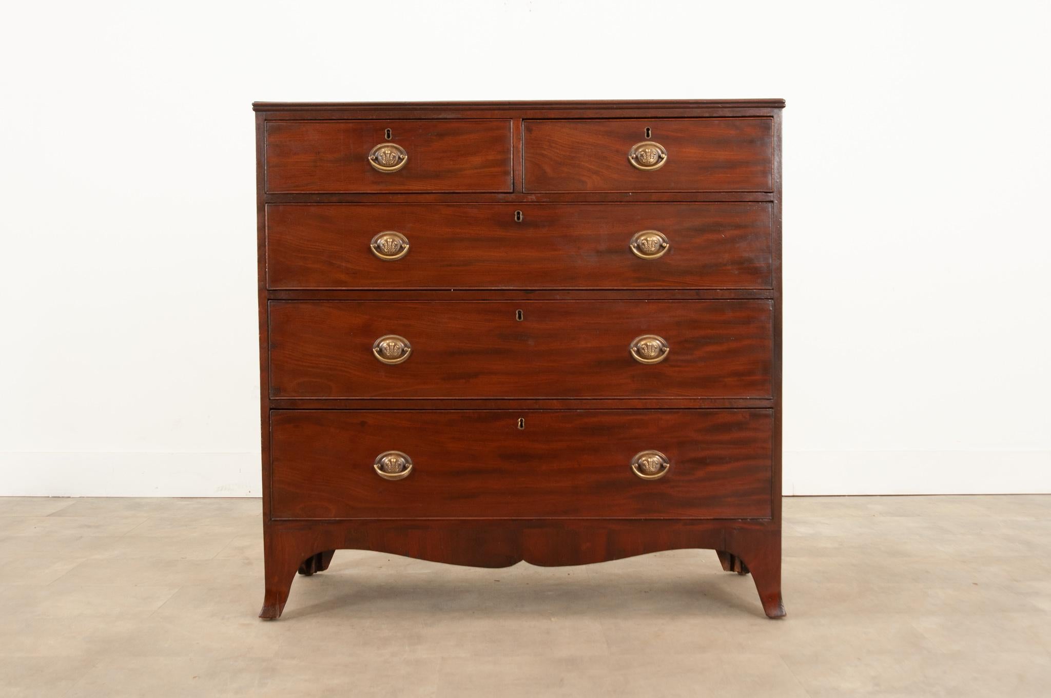 A stunning mahogany chest of drawers, made in early 19th century England, circa 1820. This five drawer case antique is made in the Georgian style and features a linear composition with extraordinarily clean lines and a polished, finished presence.