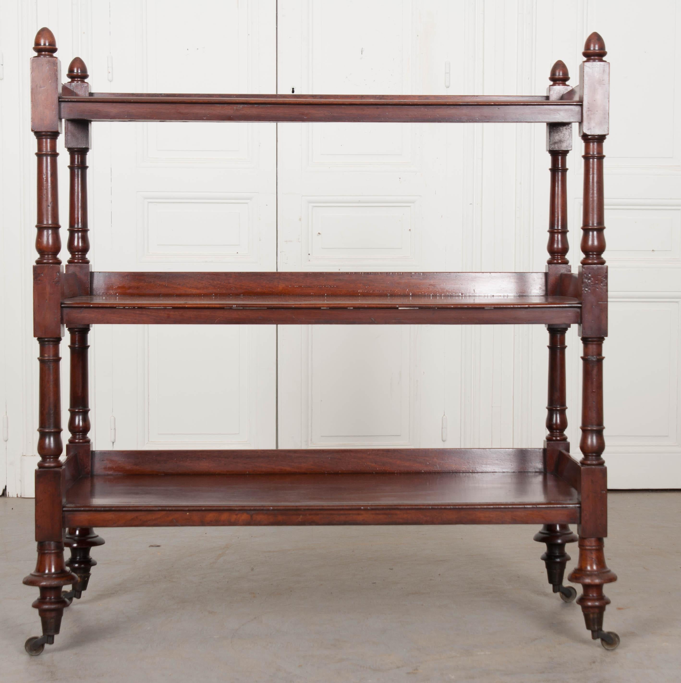 Sometimes referred to as a “dumb waiter” or “tea cart”, this antique is a top-quality English faux bamboo-carved three tier mahogany tea trolley, is from the estate f the late Michael Gray, c. 1865.  The mahogany used to create this wonderful