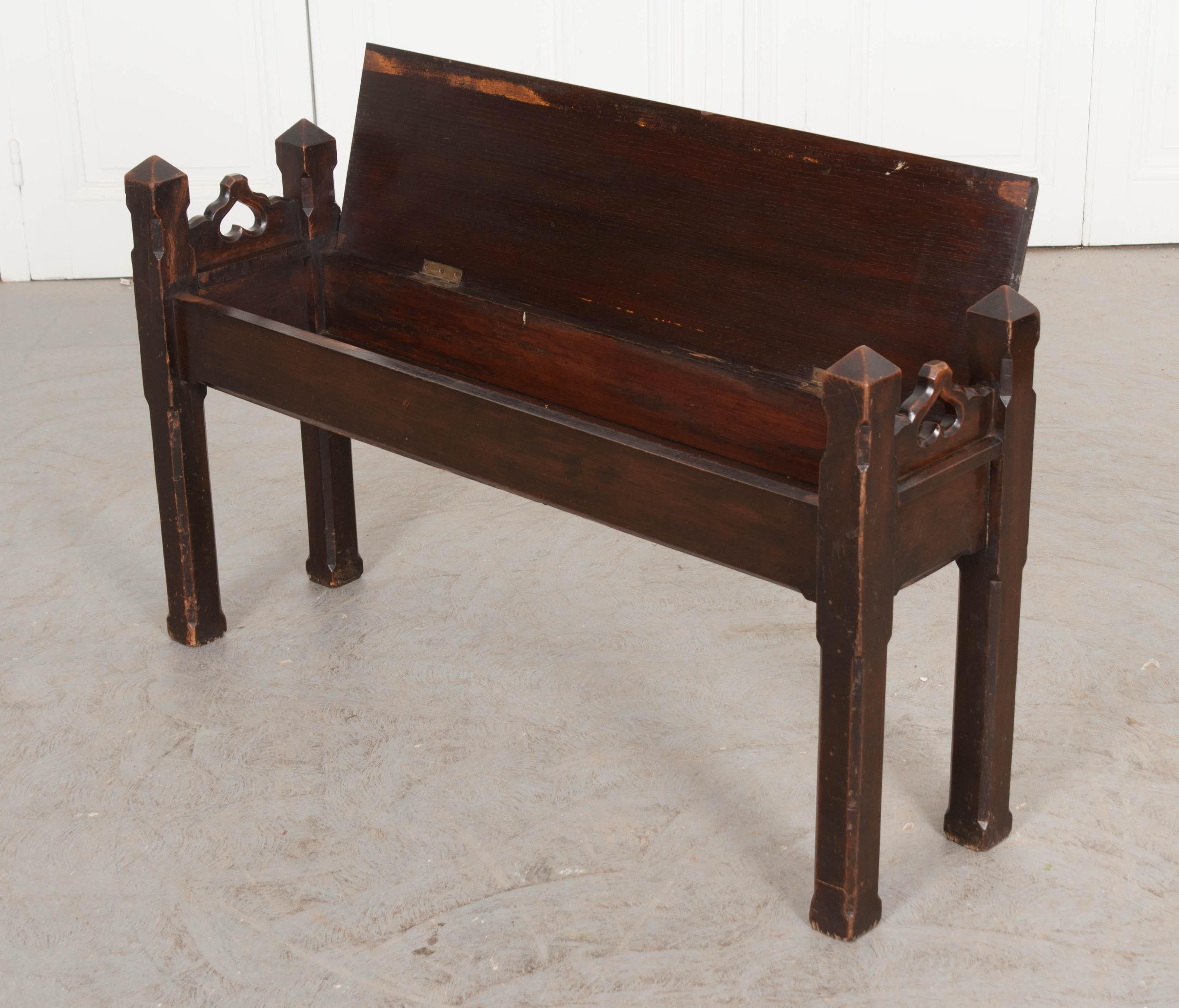 This delightful hand carved Gothic Revival oak storage bench, circa 1840s, is from England and features sweet inverted hearts in the side rails and chamfered legs. Diminutive in scale, yet multipurpose, as the seat lifts back to reveal a nicely