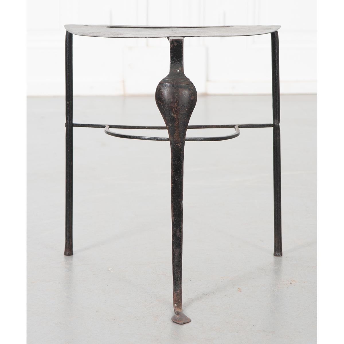 A small but lovely example of the blacksmith’s art. The hand-forged 19th century iron trivet features a flat surface to place hot pots that have come off the open fire or stove after cooking. It has two straight legs in the back and one cabriole leg