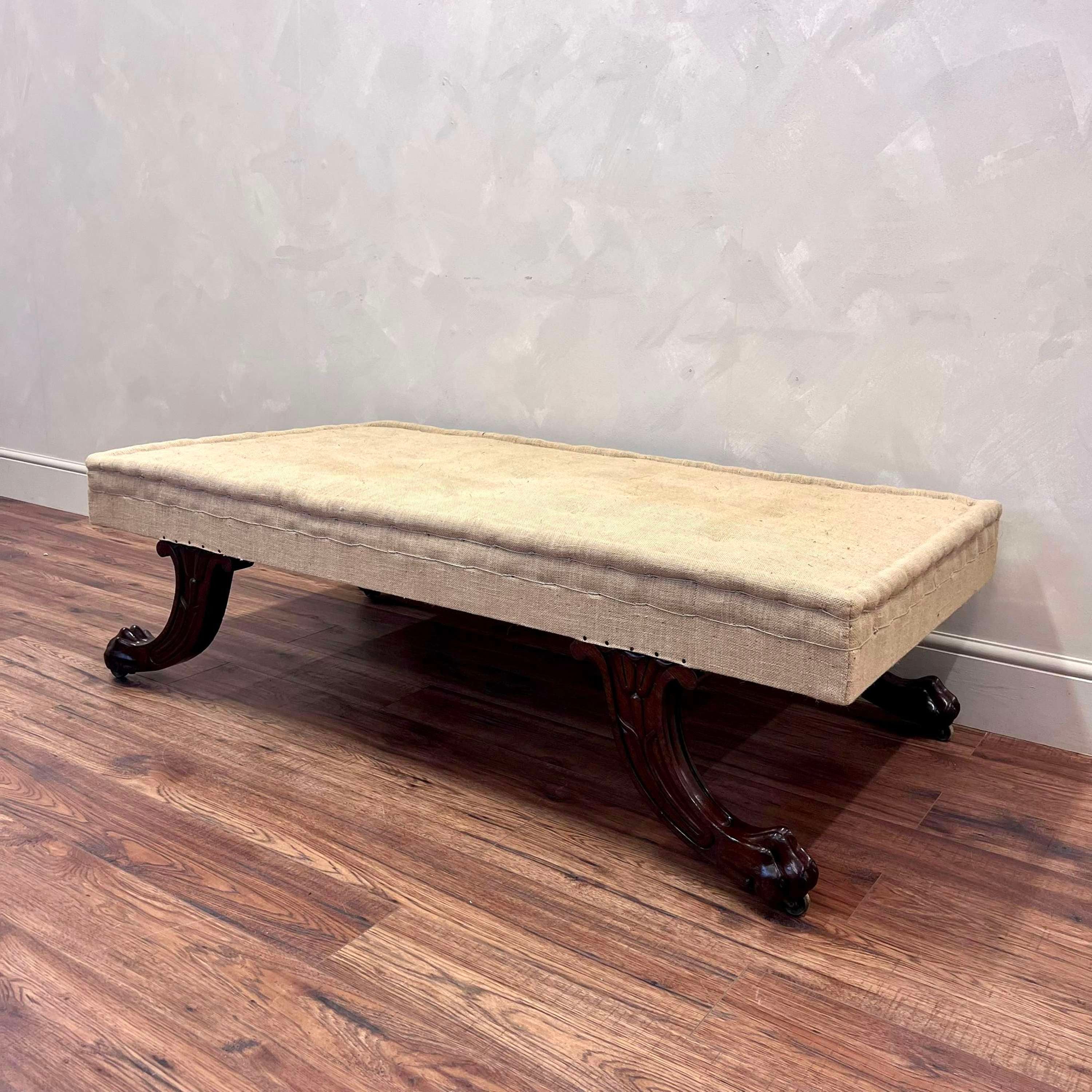 Super scale centre footstool.
The frame has been bespoke made by a joiner, using 19th century swept-away mahogany lion paw legs, on original brass castors.
The upholstery in hessian has been achieved using traditional methods, with the addition of