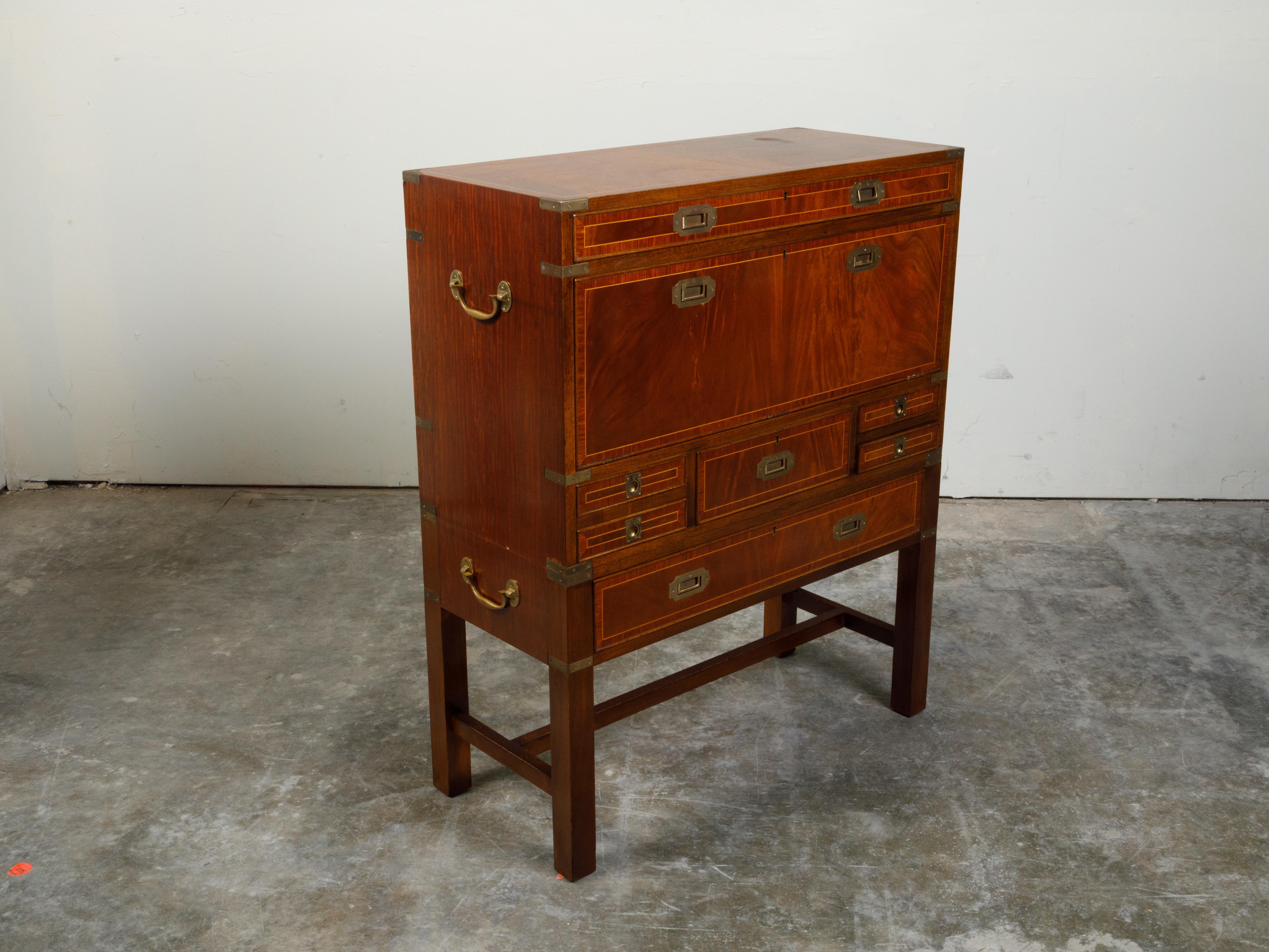 An English Campaign mahogany drop-front desk from the 19th century, with brass hardware. Created in England during the 19th century, this desk features a rectangular top sitting above a perfectly organized façade. A narrow drawer with banding at the