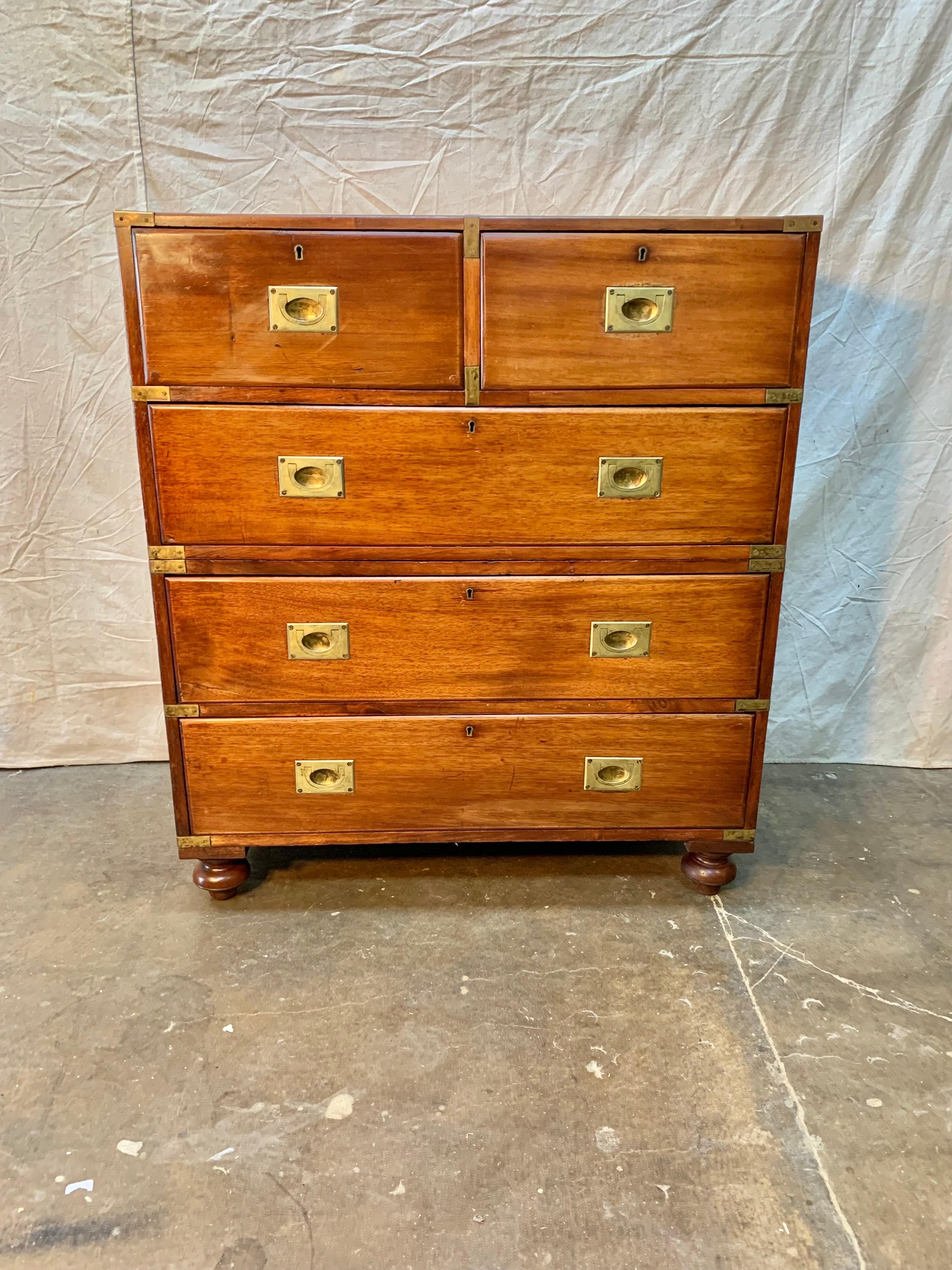 This 19th Century English Mahogany Campaign Chest of Drawers is made of two parts each flanked with side handles to allow for easier transport. The corners of the piece are covered in brass to protect them. The top portion measures 36