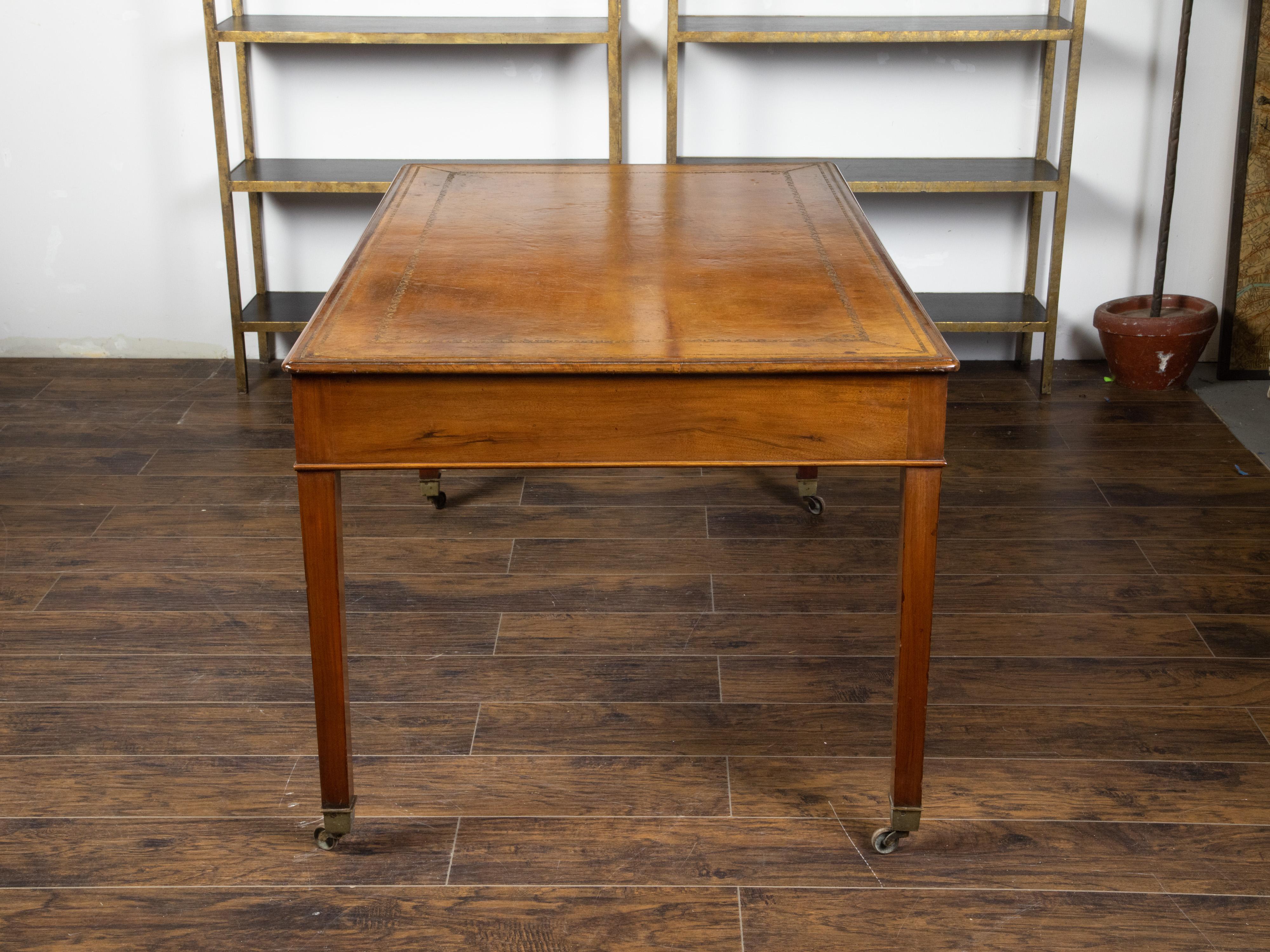 Leather English 19th Century Mahogany Desk with Three Drawers, Mounted on Brass Casters