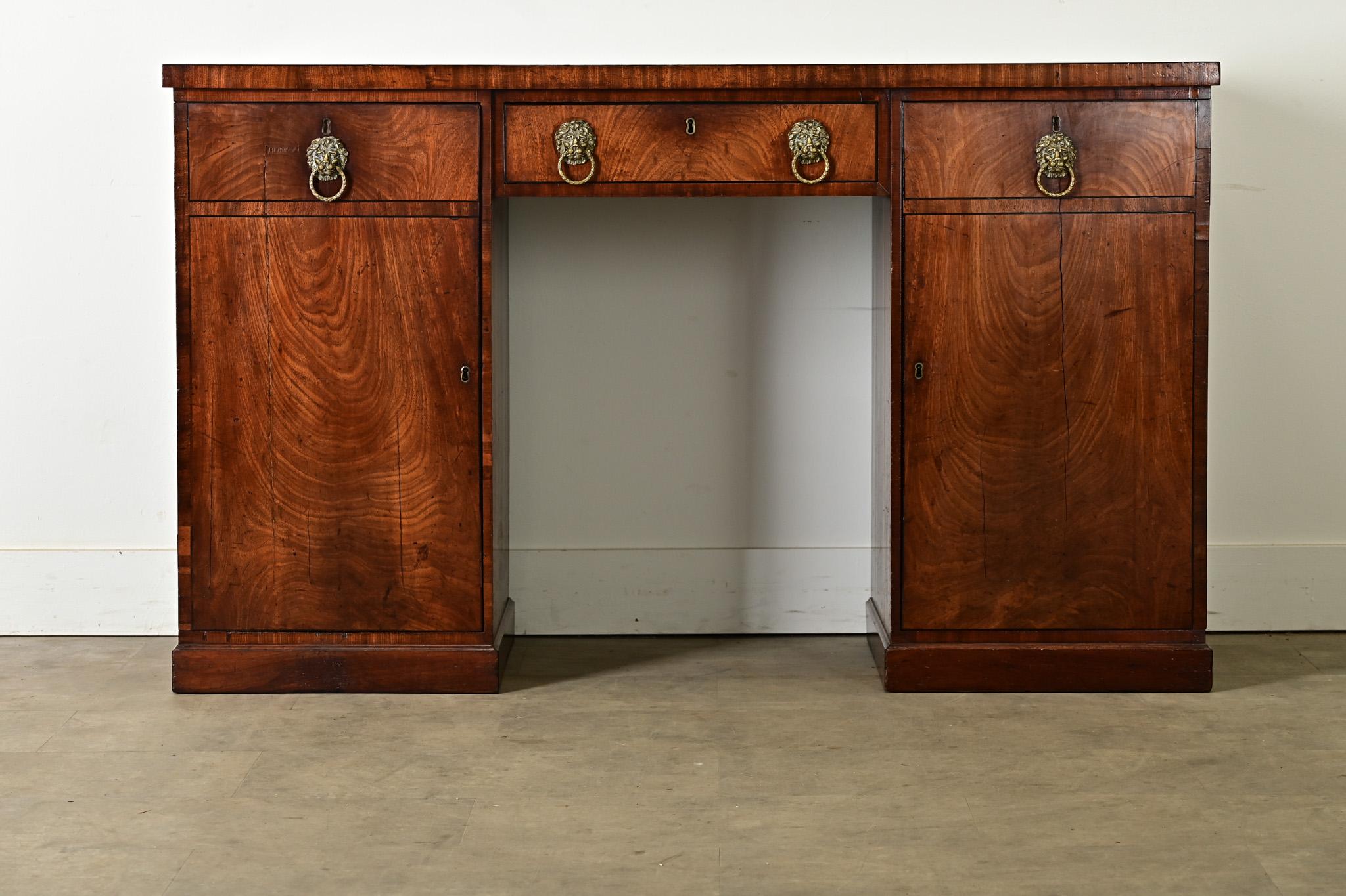 Quattro bellissimi leoni in ottone spuntano dalla facciata di questa splendida credenza Regency inglese del XIX secolo. Sono situati sull'unico cassetto centrale e sulle due ante esterne che lo affiancano. L'anta destra nasconde un interno