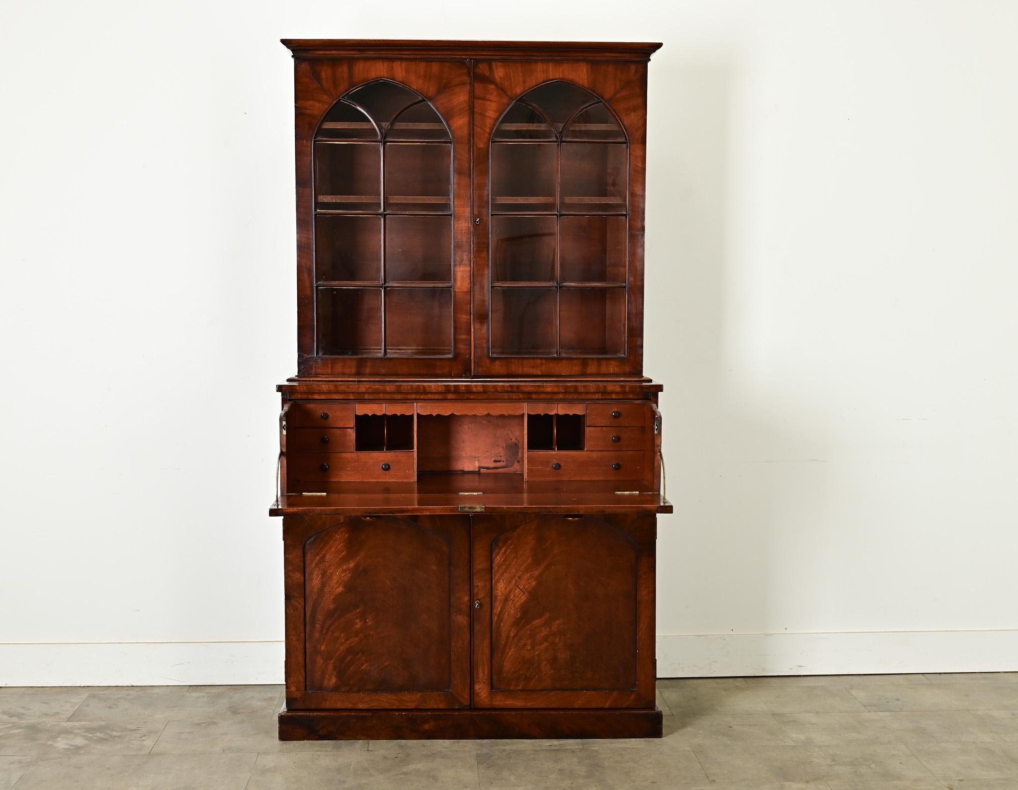 A robust mahogany secrétaire made in England, circa 1820. The secretary’s upper body features glass front doors in an arched window formation, opened by a working lock and key. Inside are three adjustable shelves at 9 ½” deep. What appears to be a