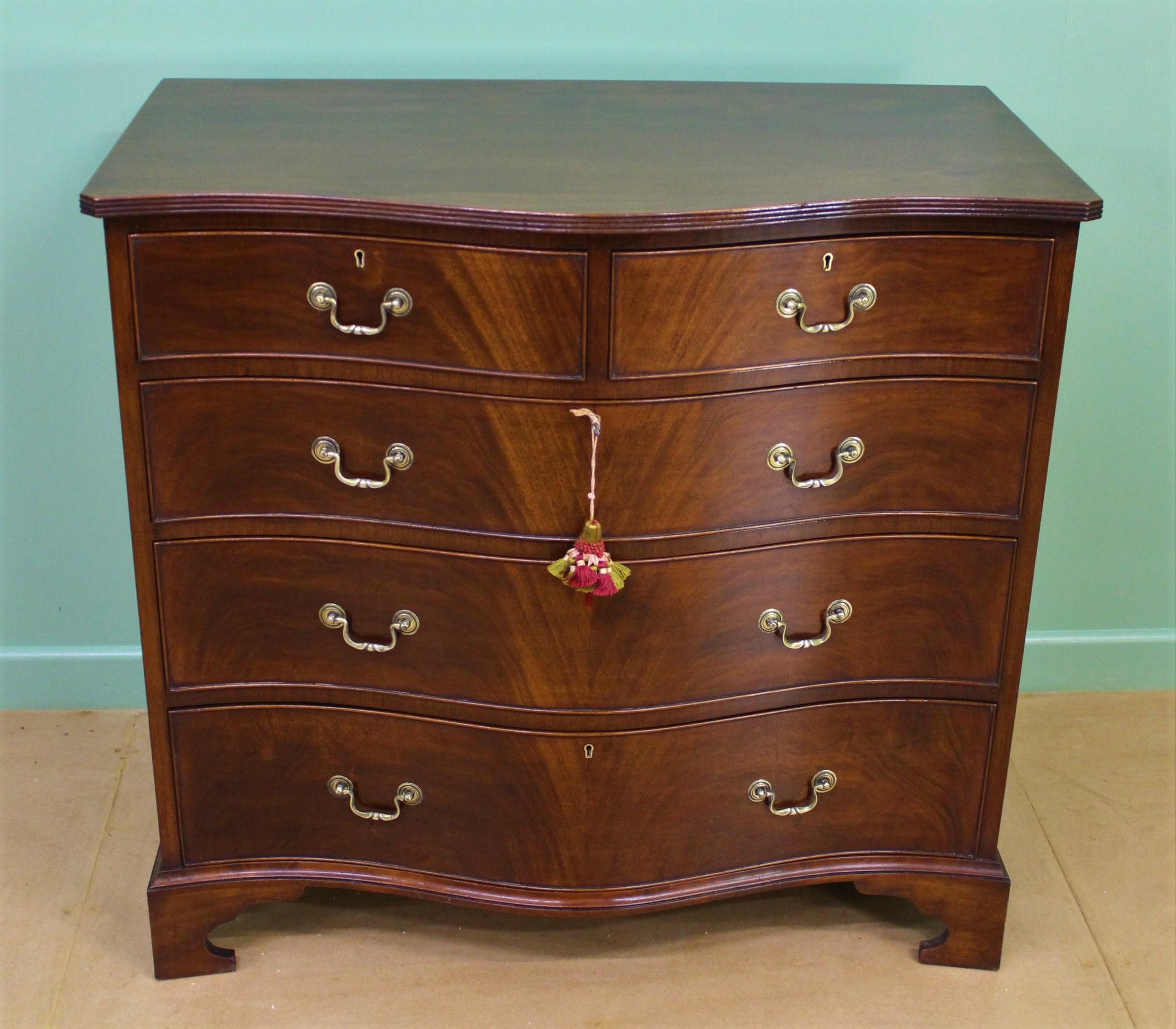 An excellent late 19th century mahogany serpentine fronted chest of drawers. Of very good construction in solid mahogany an attractive flame mahogany veneers. With a series of 2 short, over 3 long graduated drawers. All fitted with their original