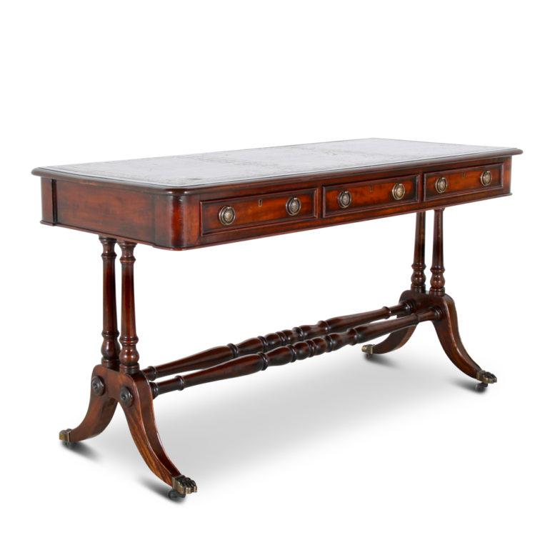 A handsome English, 19th century, mahogany writing desk or sofa table, the top with three drawers on one side and three false drawers to the other and with a gilt-tooled leather writing surface. This lovely desk is in almost mint condition