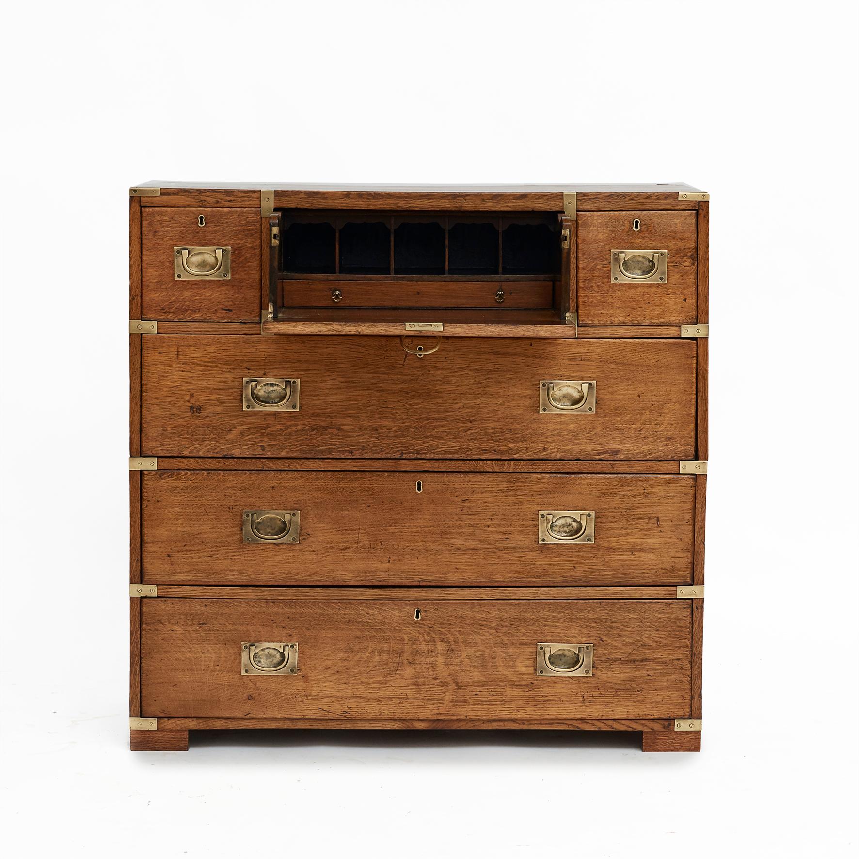 English military chest in 2 parts with writing decor.
Made in solid oak with original brass fittings.
The chest consisting of six drawers: Three smaller drawers at the top with the middle drawer opening up to a nice fitted interior with various