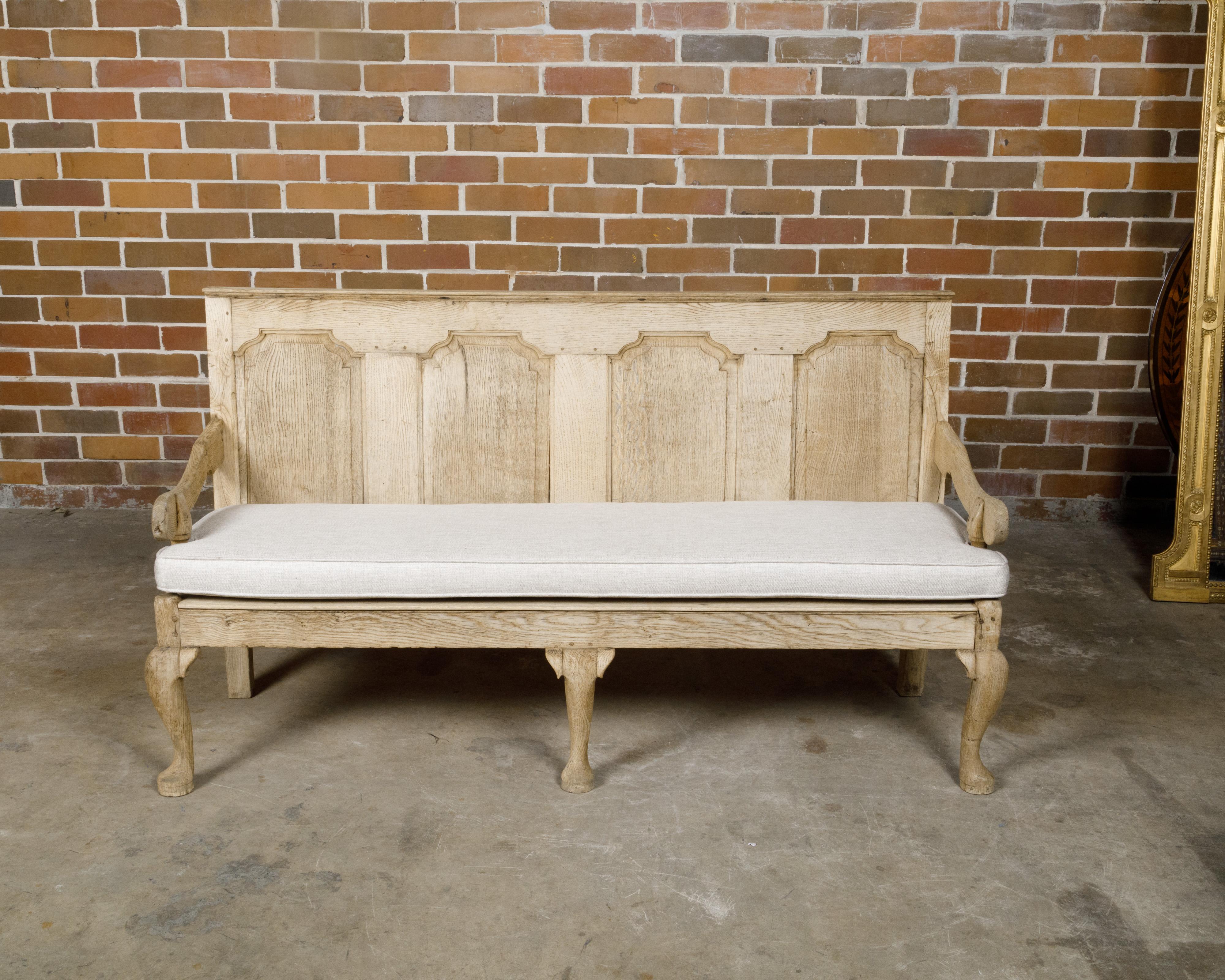 Banc anglais en chêne blanchi du XIXe siècle, avec dossier en bois sculpté, accoudoirs descendants, pieds cabriole et coussin sur mesure. Cette exquise banquette anglaise en chêne blanchi du XIXe siècle présente un dossier en bois magnifiquement