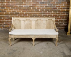 English 19th Century Oak Bench with Carved Back, Downswept Arms and Cushion