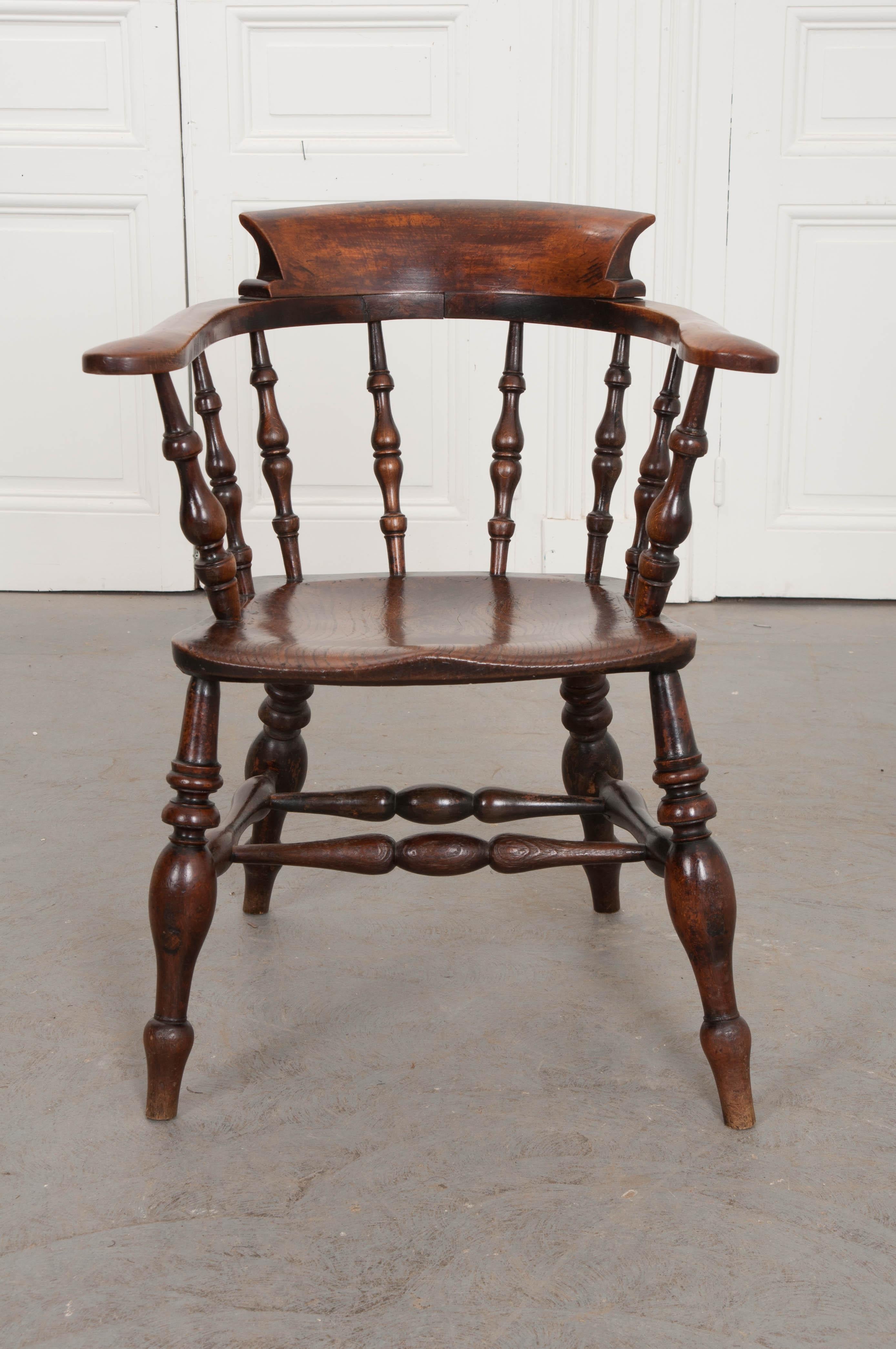 A splendid captain’s chair, made in England, circa 1870 of solid oak. The antique has fantastic turned spindle components that join to form a handsome and classically styled chair. The horseshoe shaped armrest, welled seat, and curved top rail have
