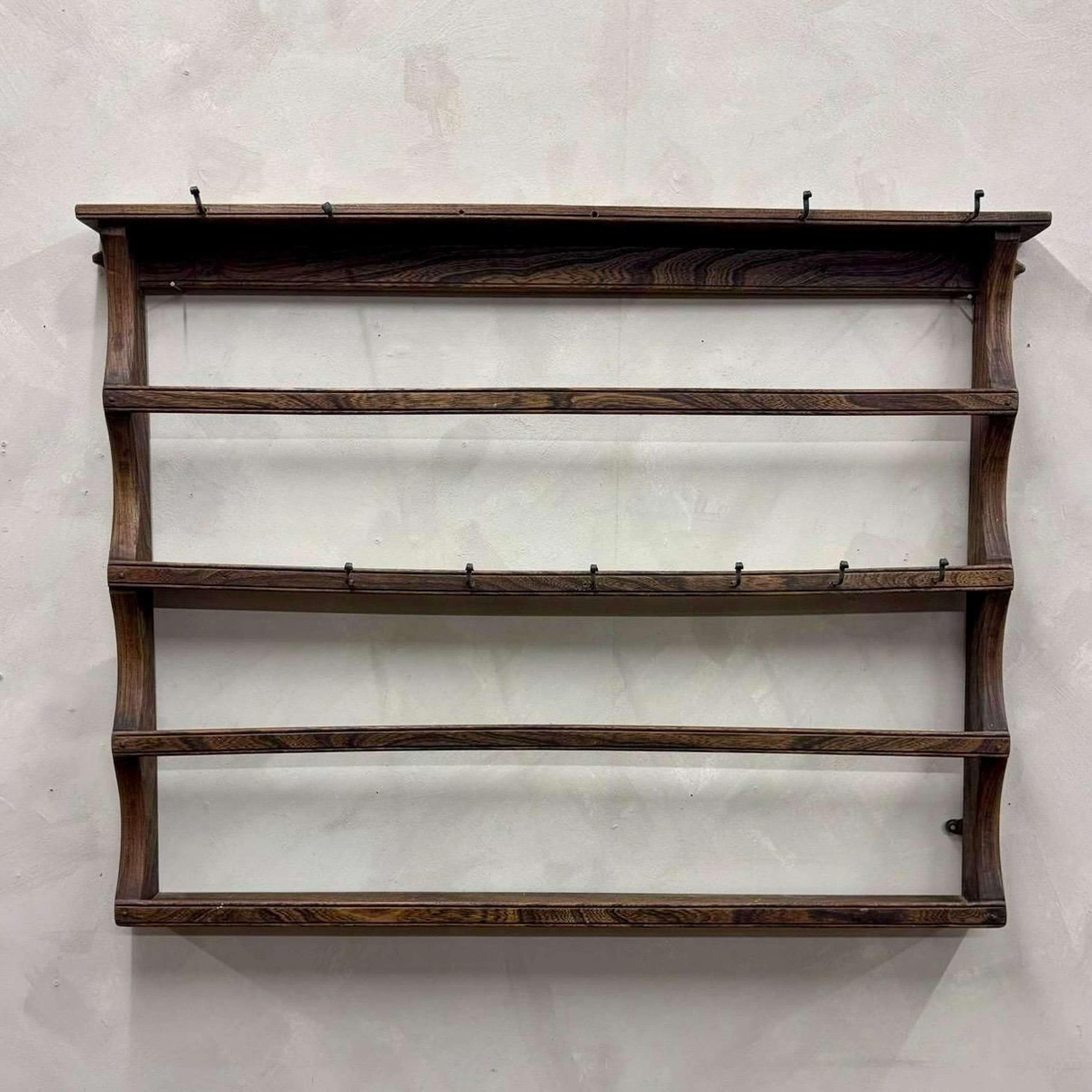 Oak country house plate shelf, with rose headed nails, holding together the worn stretchers.
With iron hooks for holding cups.
England,  circa 1880.

Width - 112 cm
Height - 84 cm
Depth - 8 cm
Please message if any further info or photos are