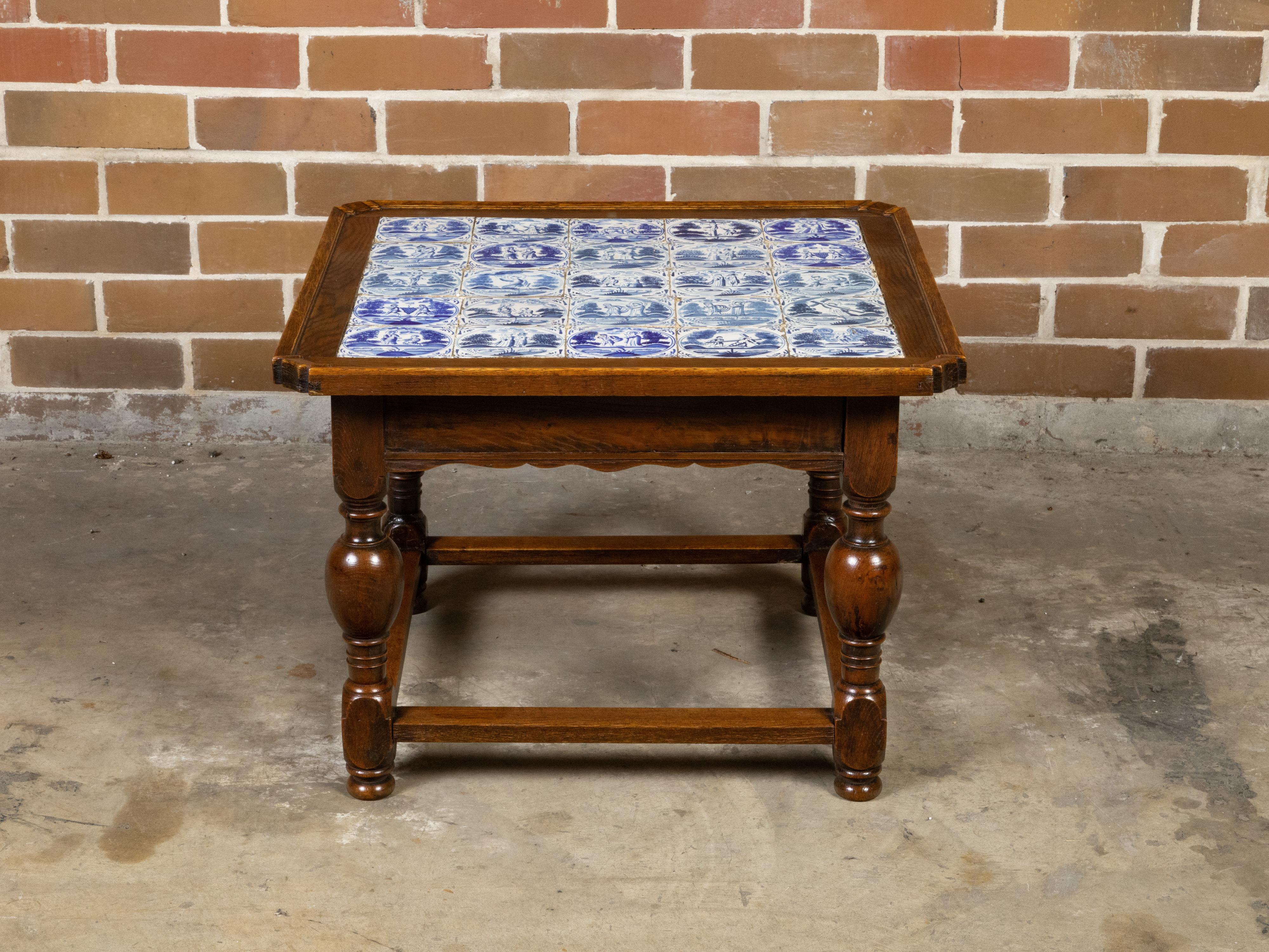 An English oak drinks table from the 19th century with blue and white Delft tiles top depicting religious scenes, and resting on turned legs. Created in England during the 19th century, this oak drinks table features a square top beautifully adorned