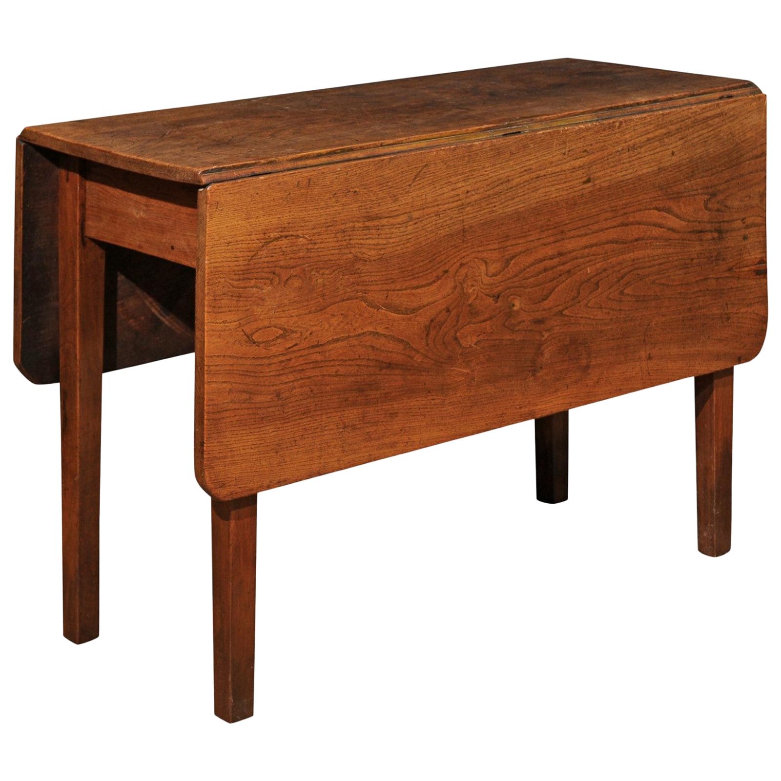 An English oak drop-leaf table from the 19th century, with gateleg base. Created in England during the 19th century, this oak table features a rectangular top with rounded corners made of two drop leaves resting upon a gateleg base once open. The