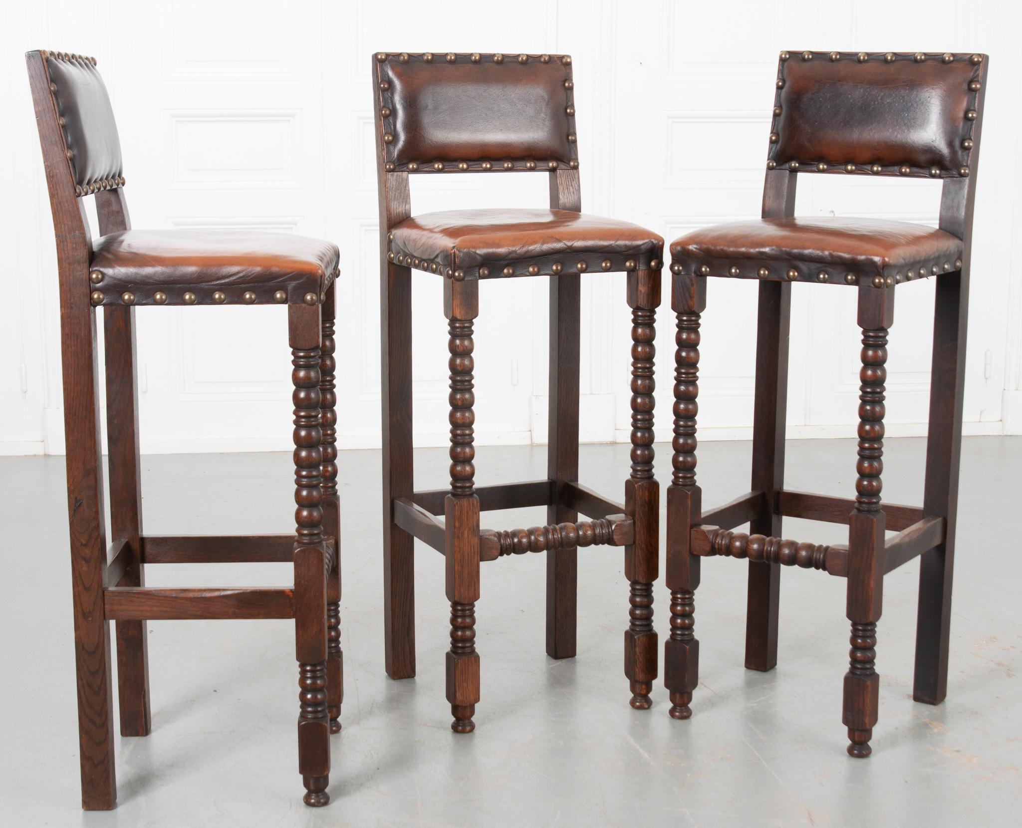 Sold as a set of three, these 19th century oak and leather chairs are in amazing condition. The leather is supple and durable, varying in shade depending on where it has been most used. The chair back and seat are both padded and comfortable. The